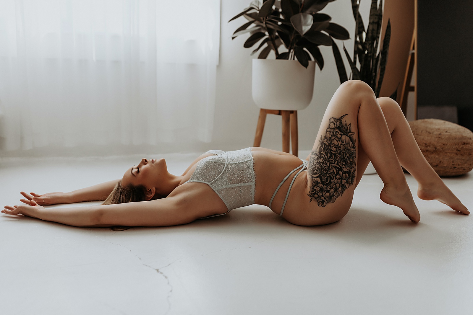 Woman in pale lingerie set lying on the floor for boudoir session with Minneapolis photographer, Mary Castillo 