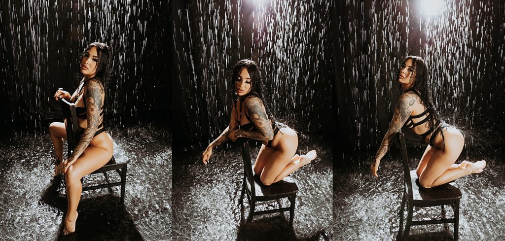 Woman in black lingerie kneeling on a chair under a rain at photo shoot. 