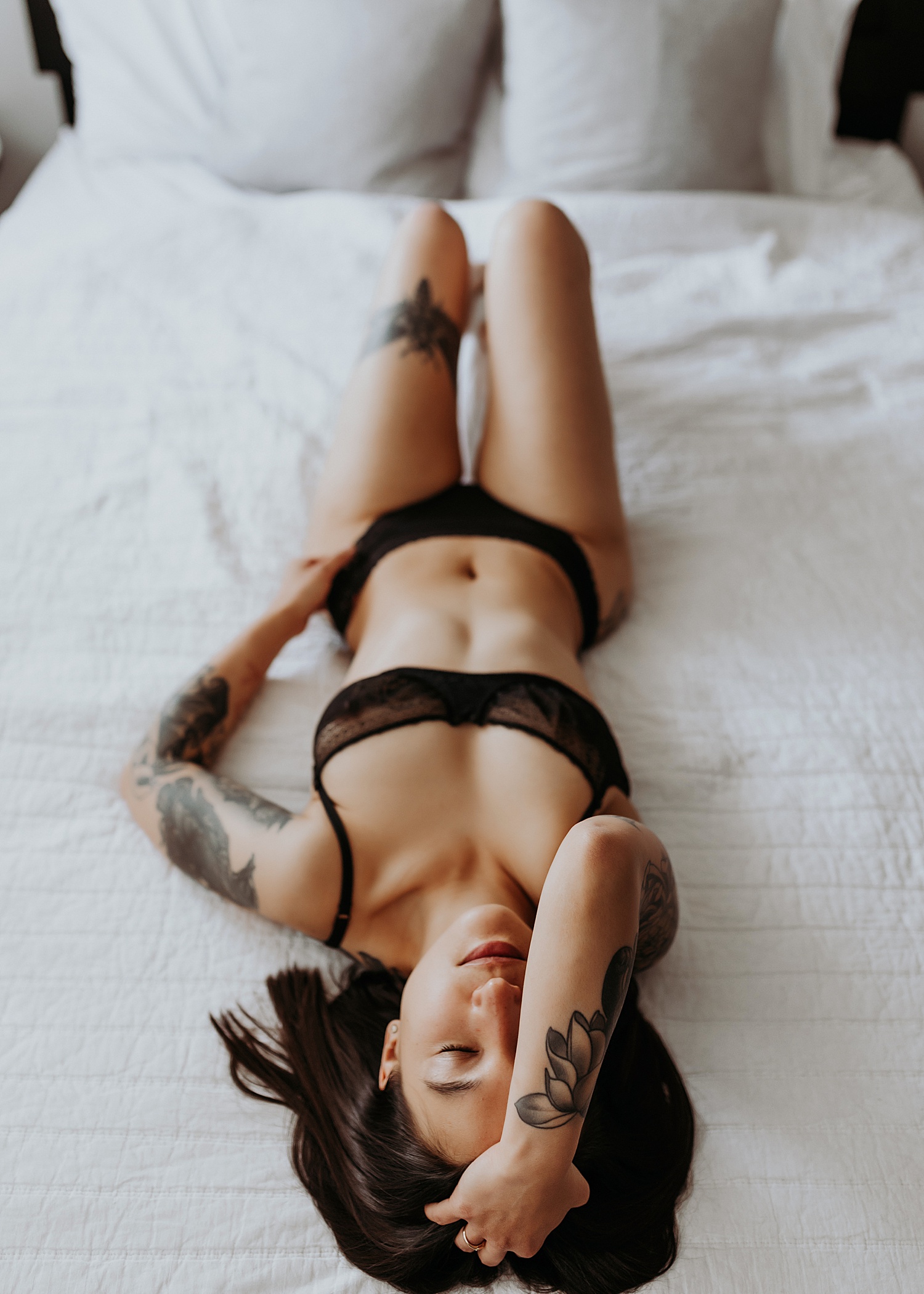 Woman in black lingerie lying on a bed for Denver Boudoir Session