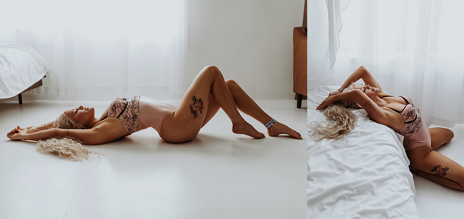 Blonde woman in pink & black floral lingerie lying across the floor for sexy photo shoot