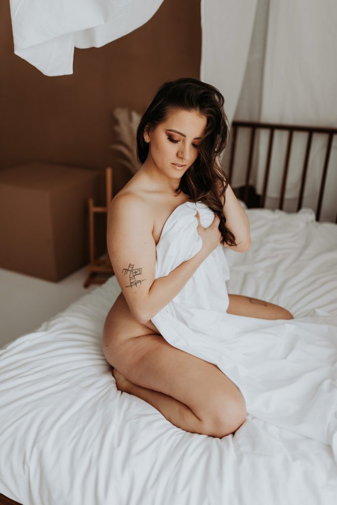 Nude woman covering herself with a sheet 
