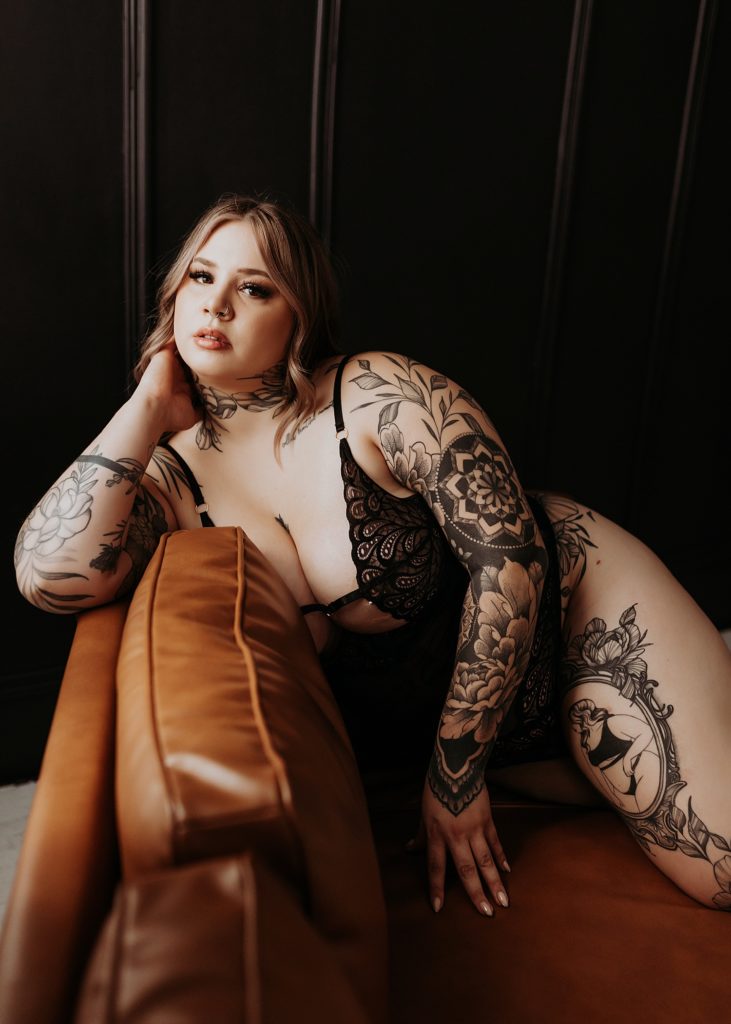 woman with full sleeve of tattoo on couch for Spicy Studio Shoot