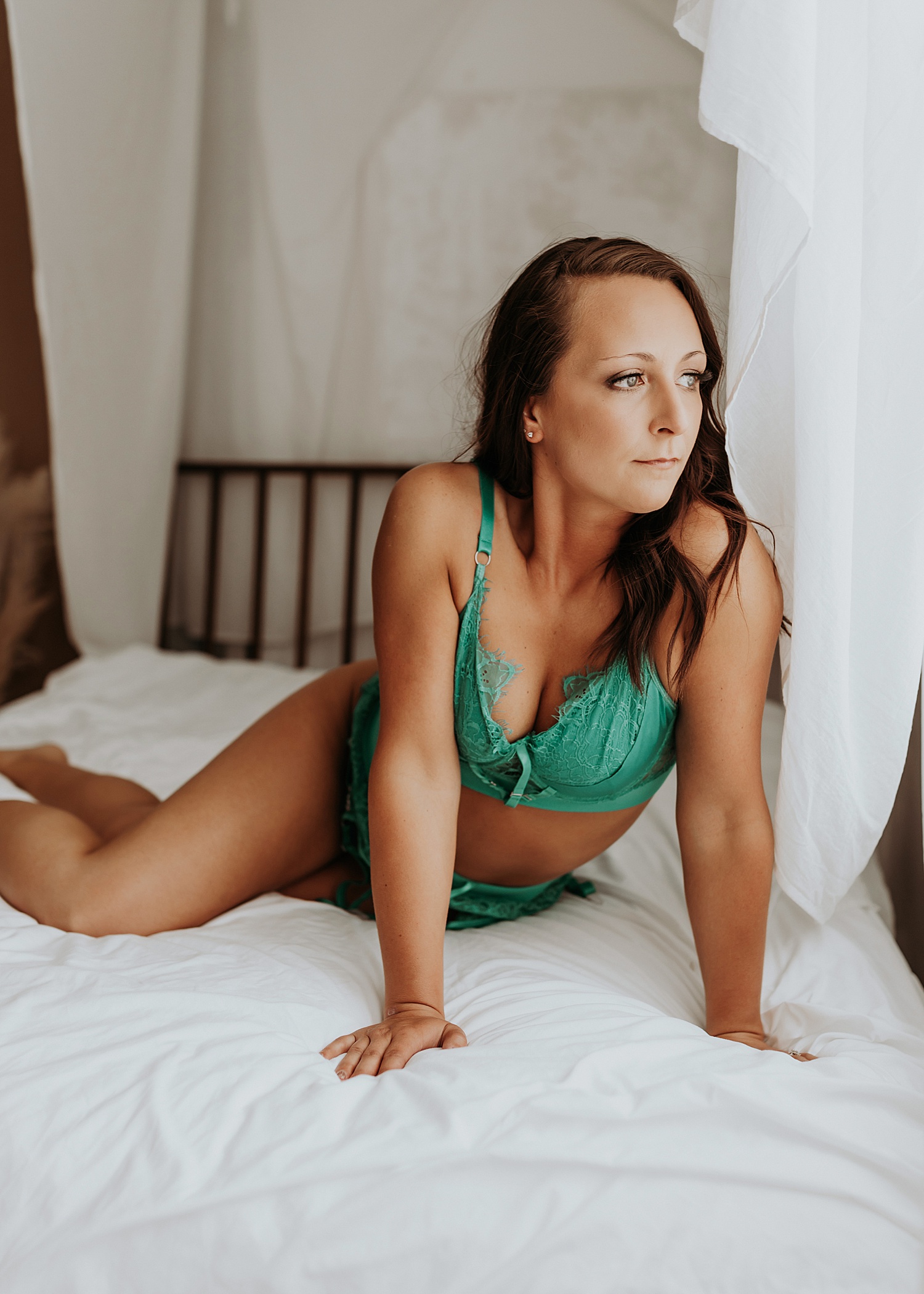 woman lying on bed in teal lingerie for spicy bride shoot 