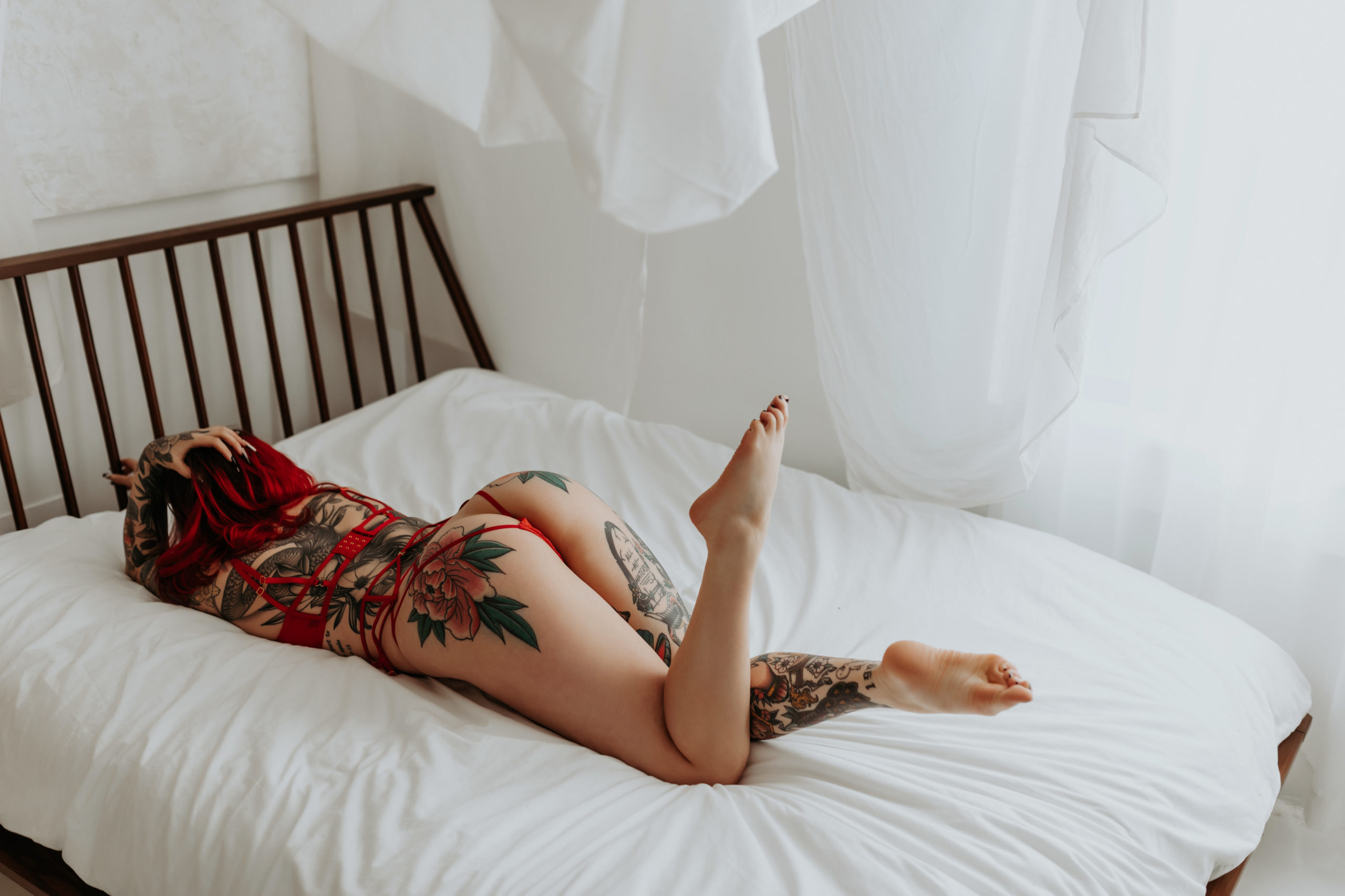 Laying on bed, lady grabs hair for Mary Castillo Photography