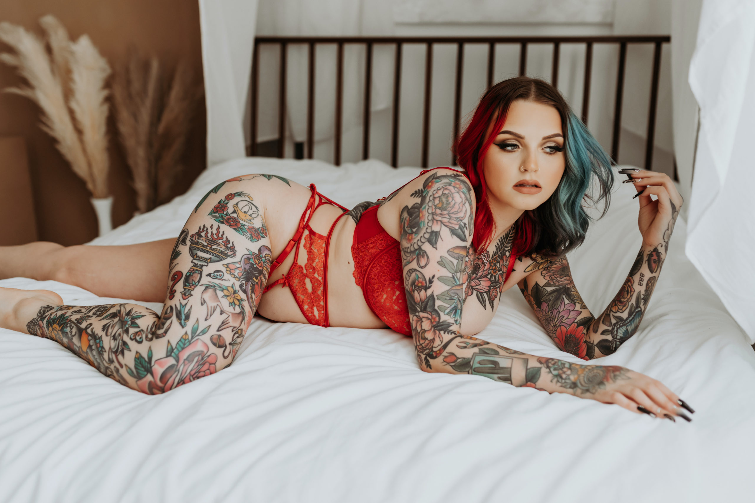 Model and Makeup Artist lays onto bed and plays with hair