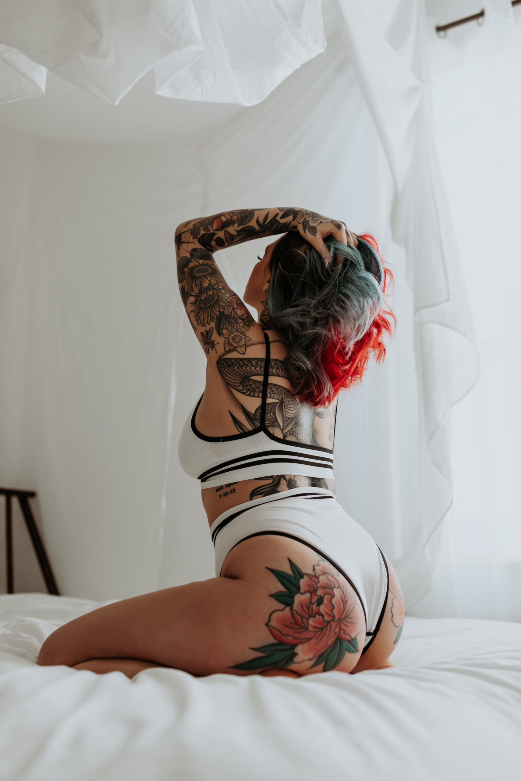 Lady grabs hair while kneeling on bed for Mary Castillo Photography
