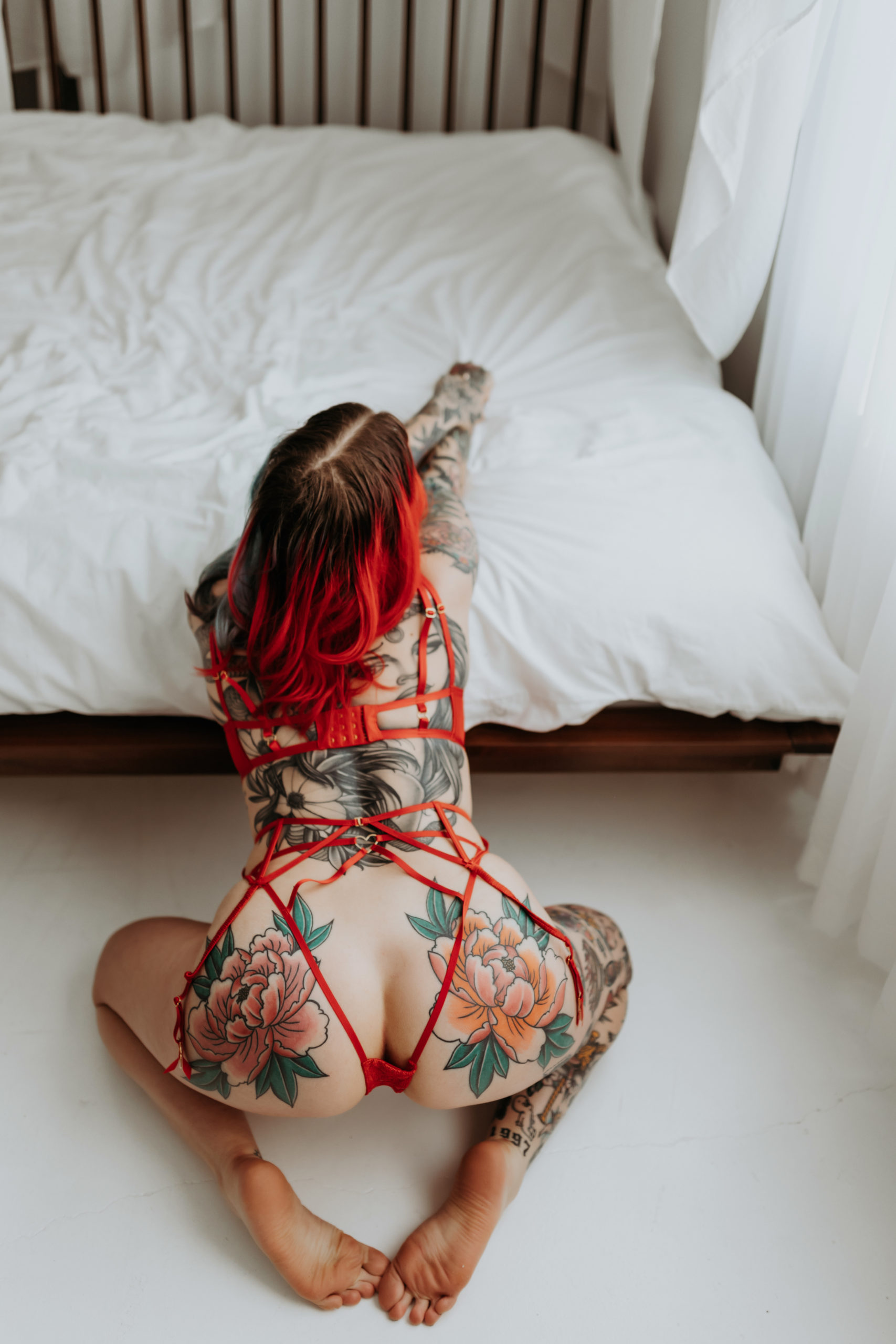 Woman leans on knees to edge of bed for Minneapolis Boudoir Photographer