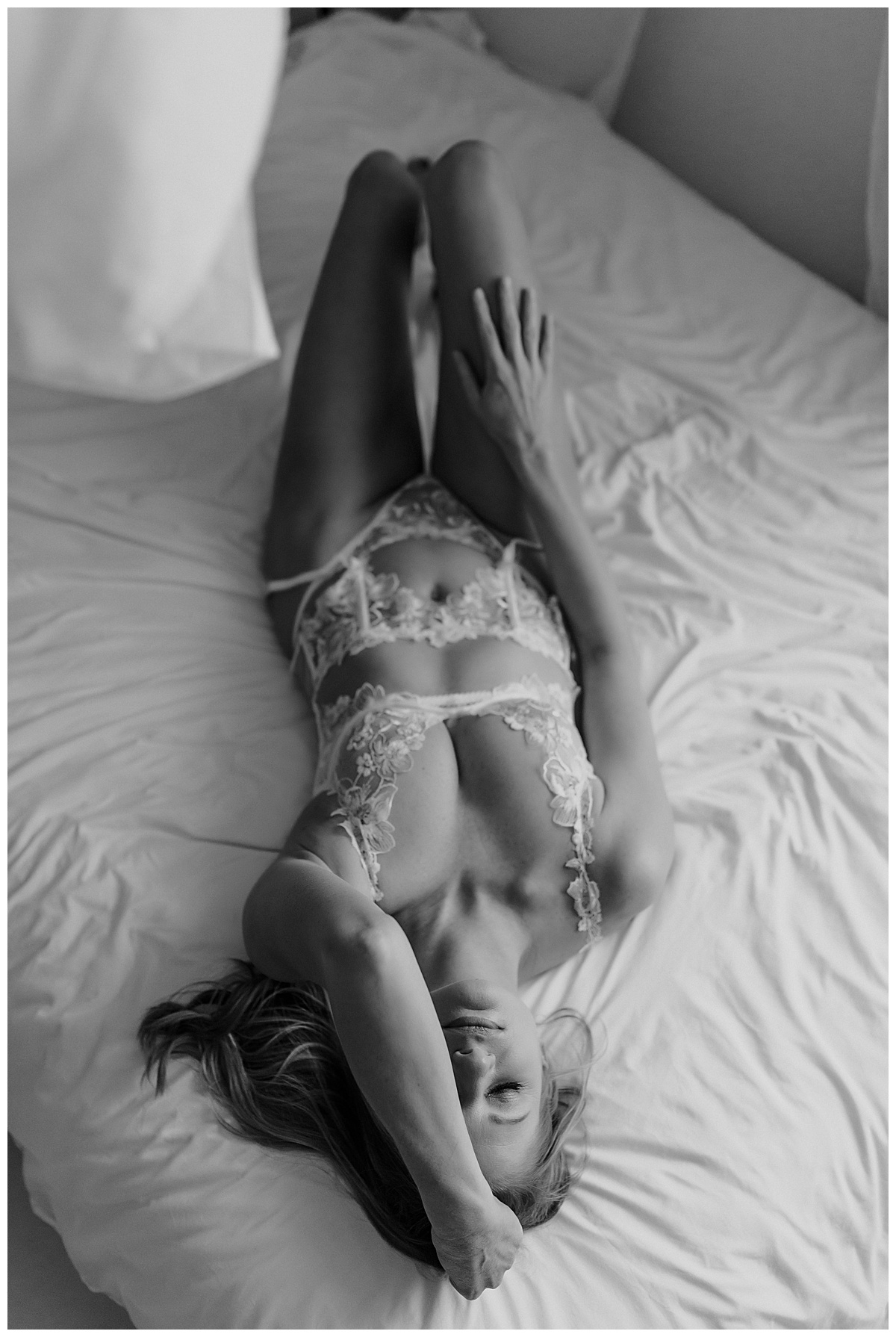 Adult laying on bed in white lingerie for Minneapolis Boudoir Photographer