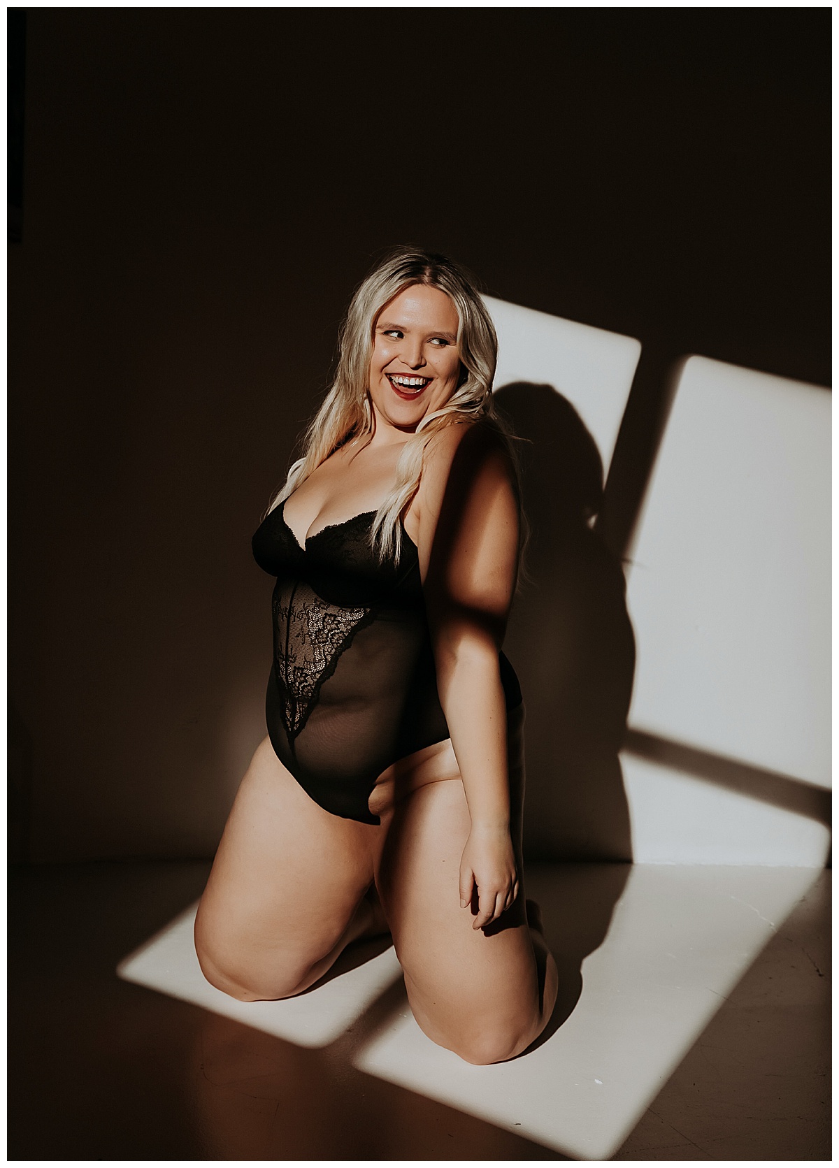 Blonde smiles big in black lingerie for Minneapolis Boudoir Photographer