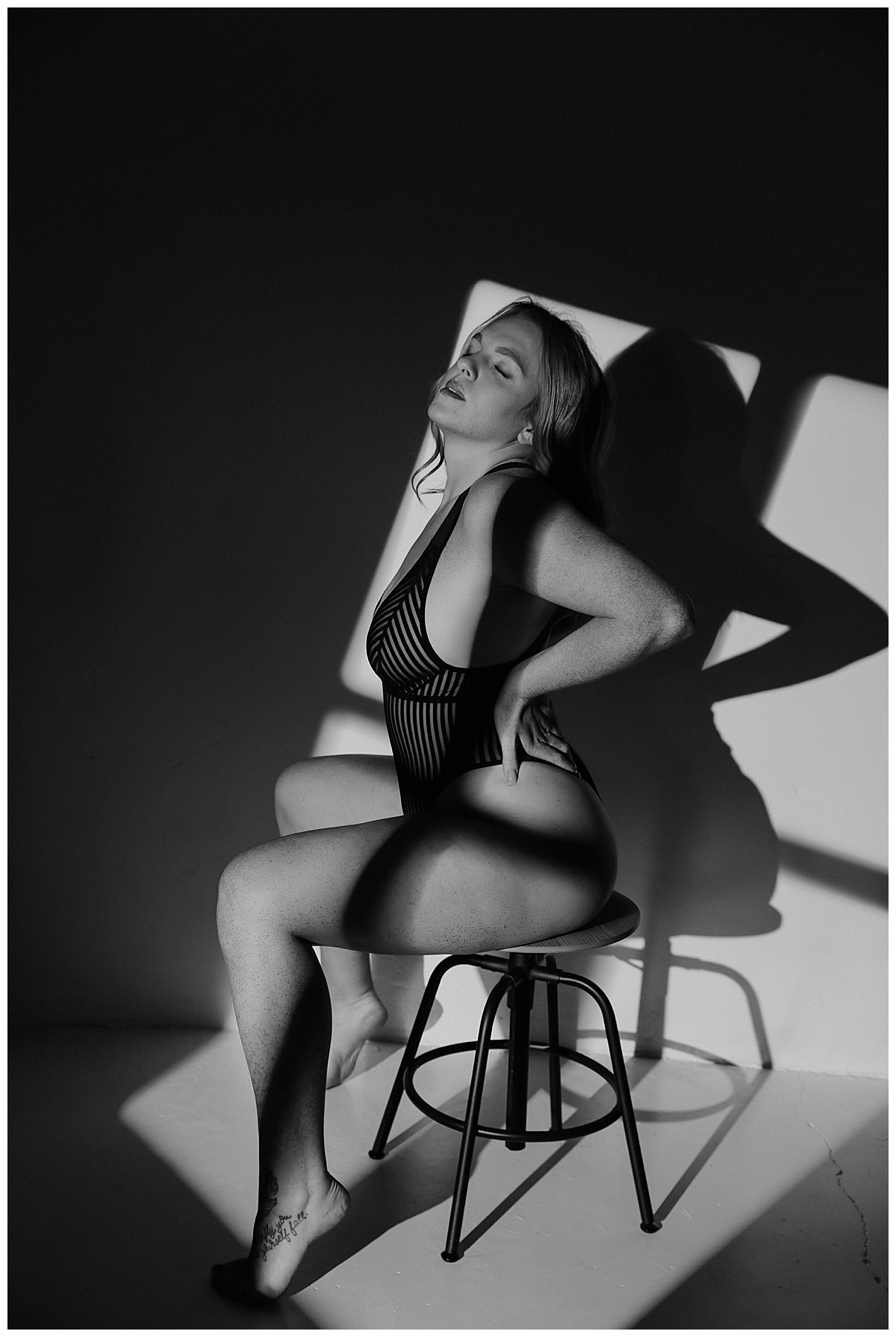 Female sits on chair in lingerie for Minneapolis Boudoir Photographer