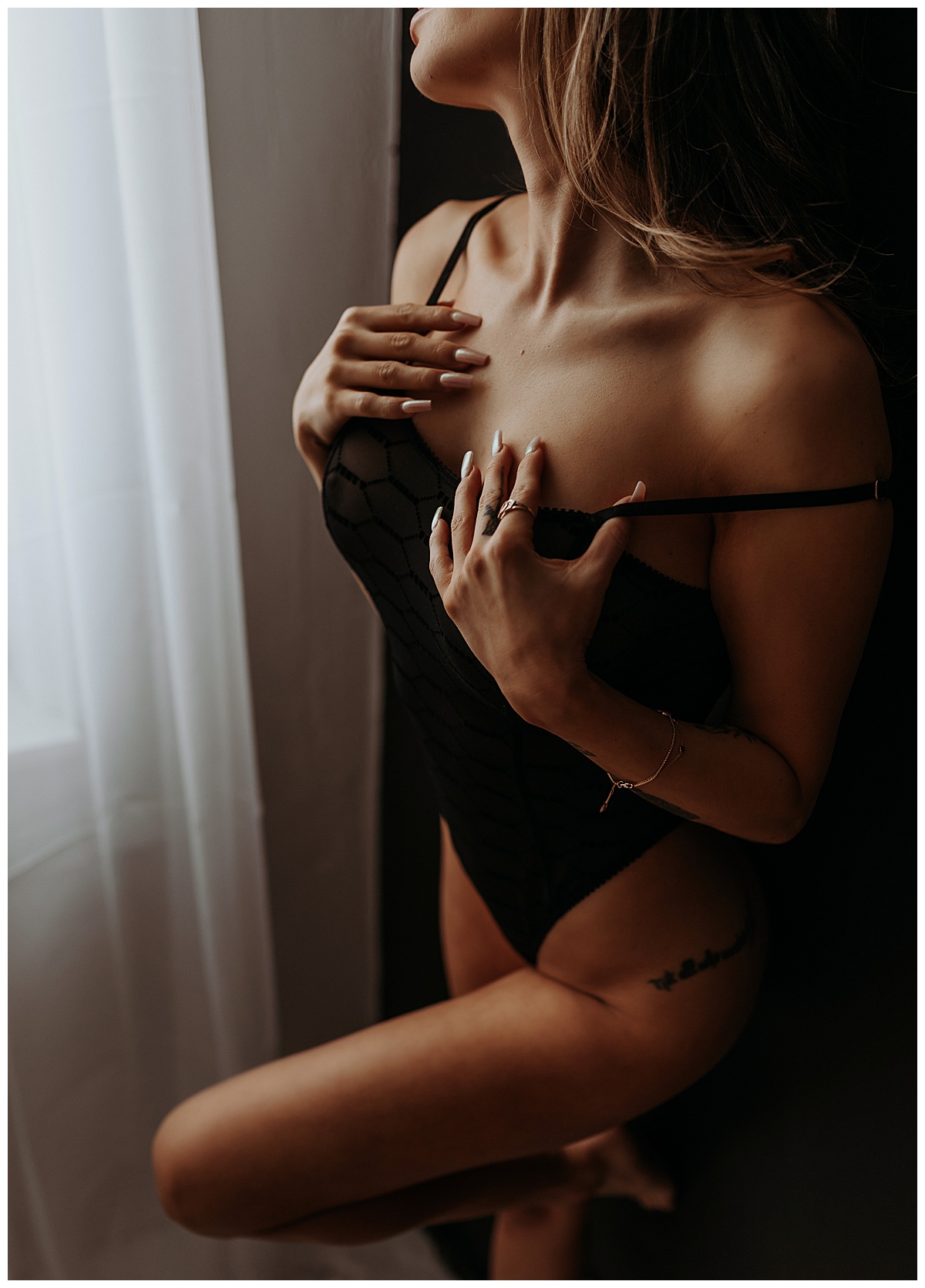Female grabs chest in black lingerie for Mary Castillo Photography