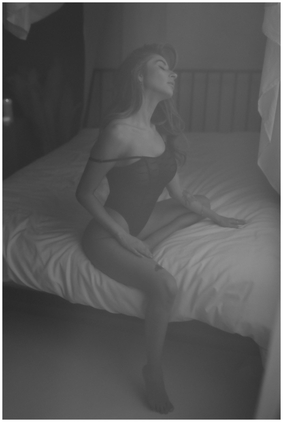 Female leans over bed not in Honey Birdette lingerie