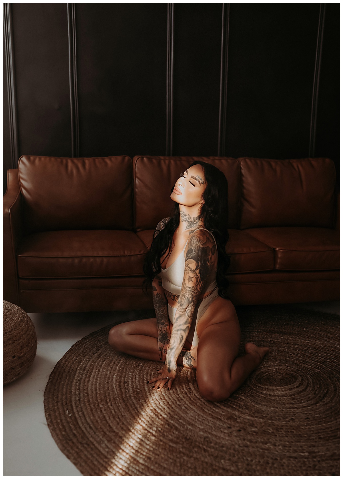 Tattooed woman sits in light for Mary Castillo Photography