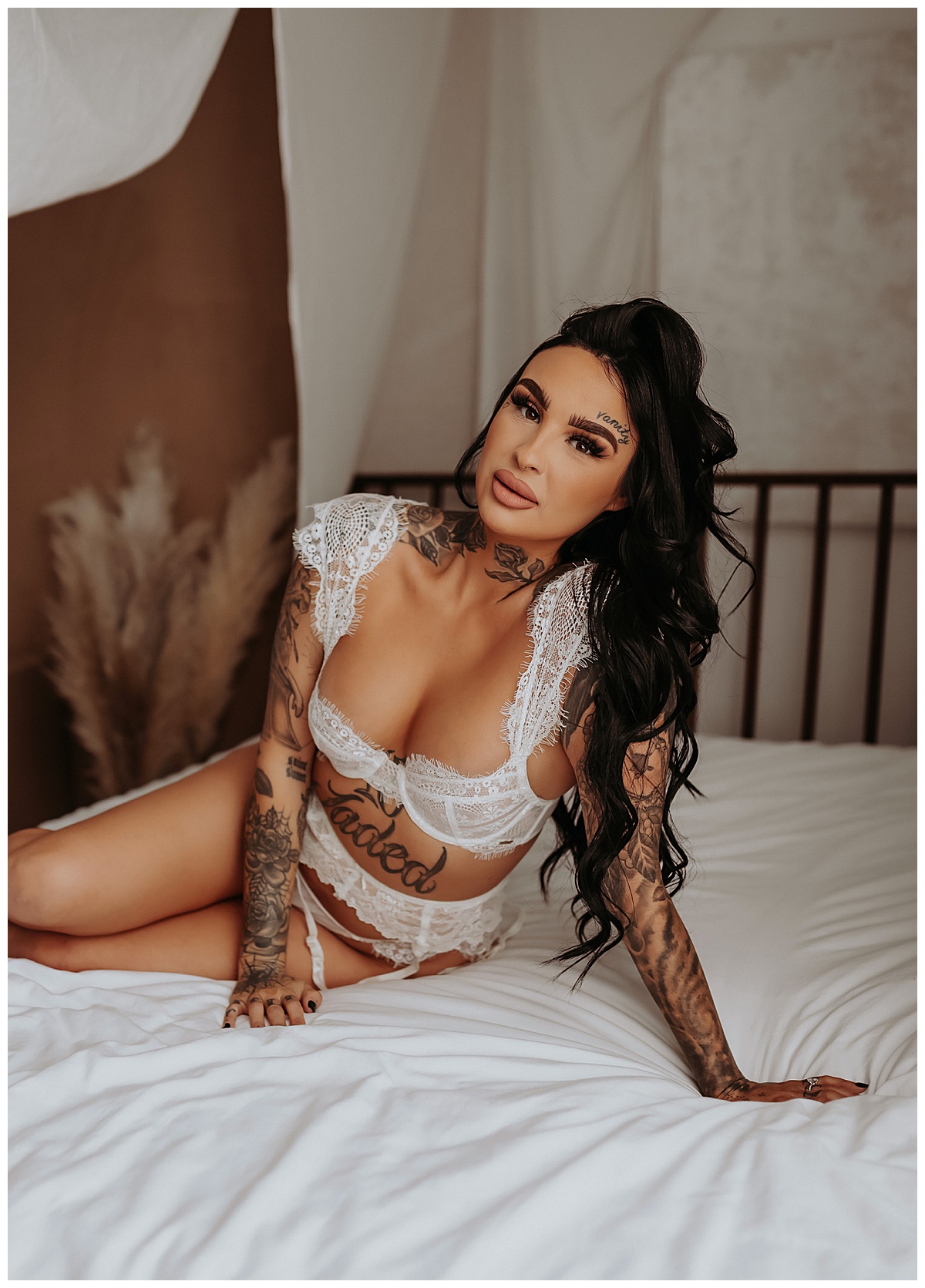 Woman kneels on bed in white lingerie for Mary Castillo Photography