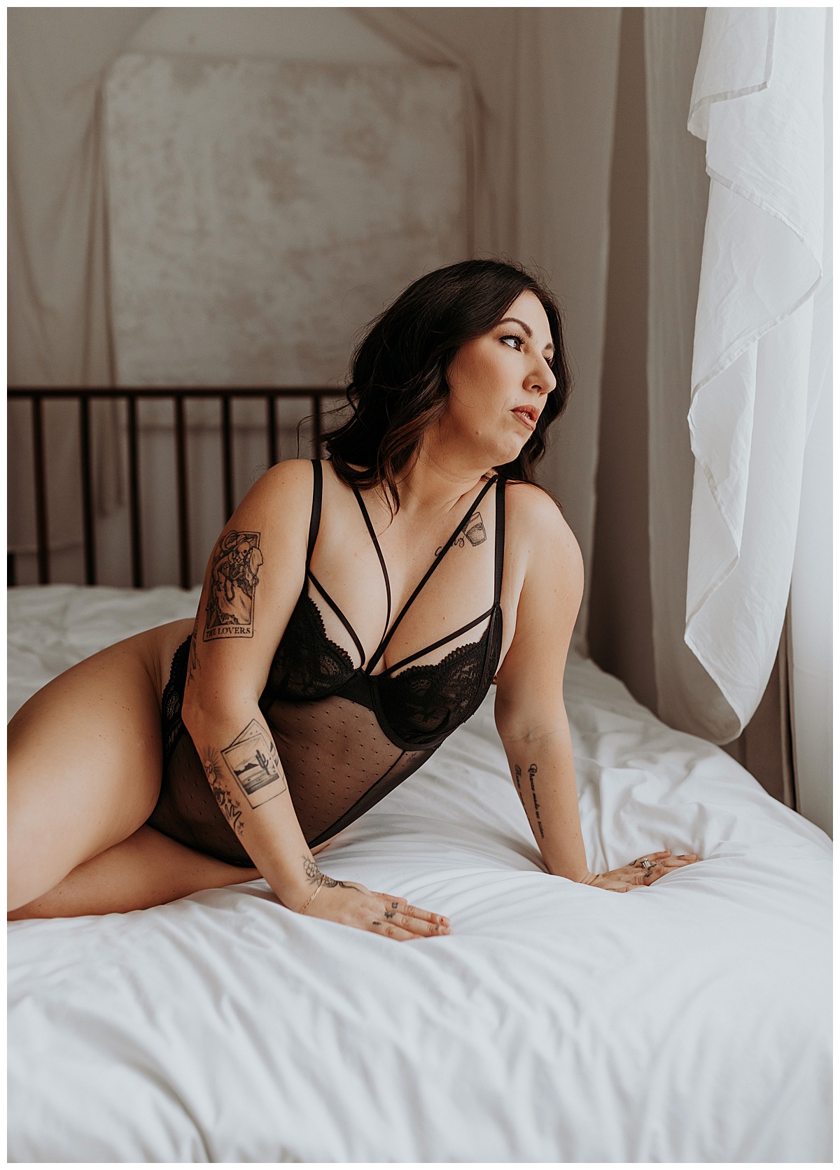 Lady looks out window on bed for Minneapolis Boudoir Photographer