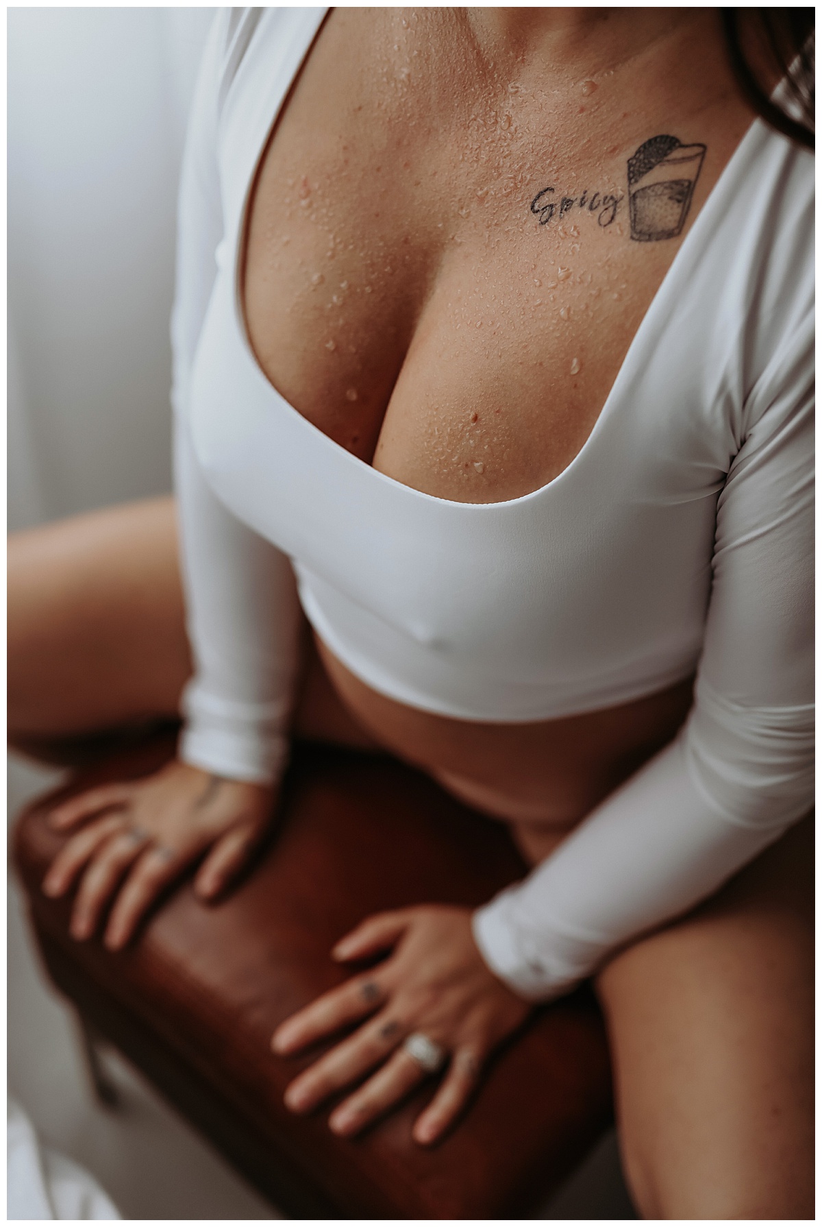 Tattooed woman in white shirt sits on chair Mary Castillo Photography