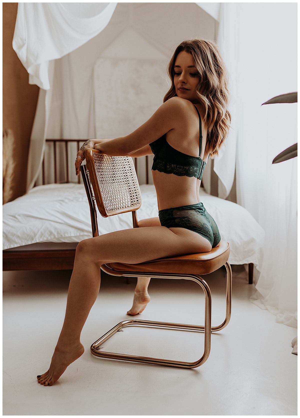 Brunette sits on chair embracing warm sunset glow vibes in green lingerie 
