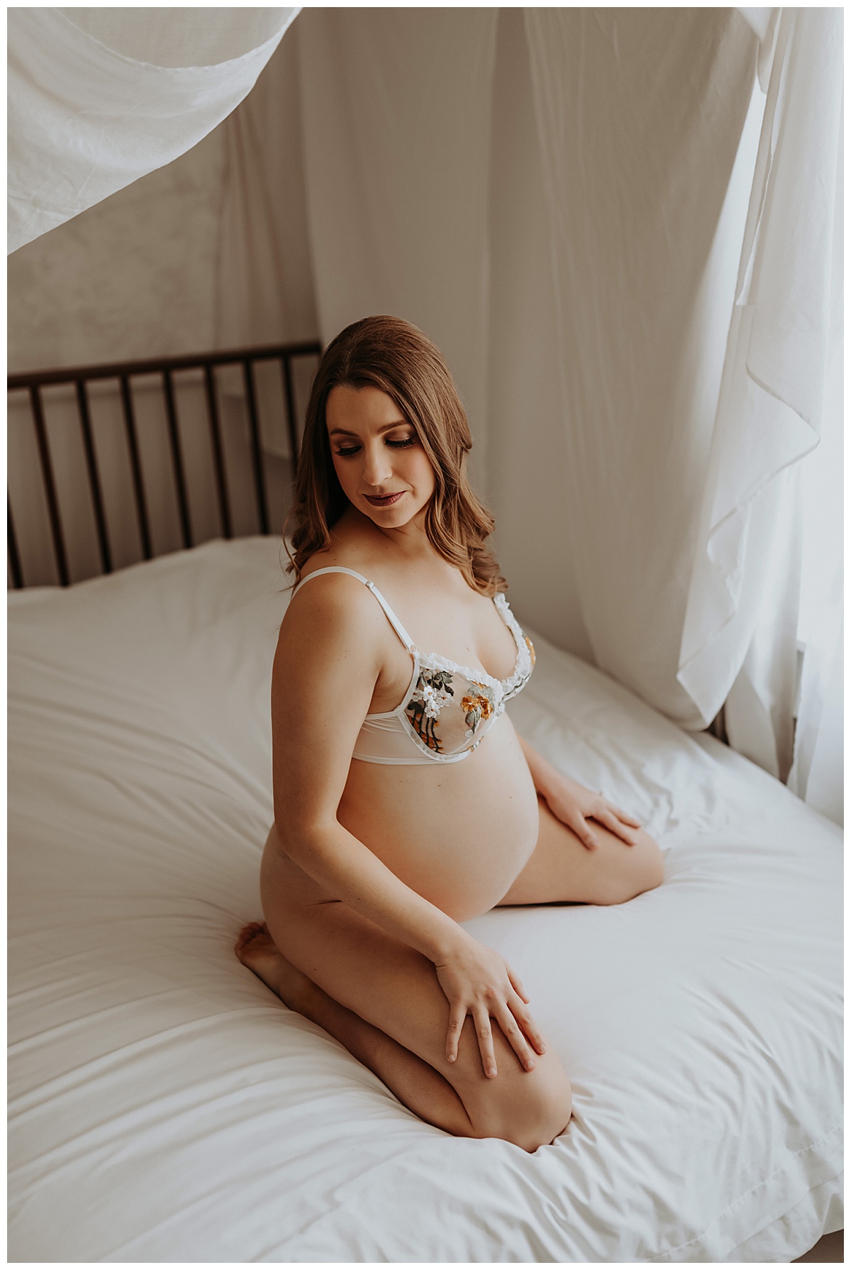 Pregnant woman kneels on bed for Mary Castillo Photography