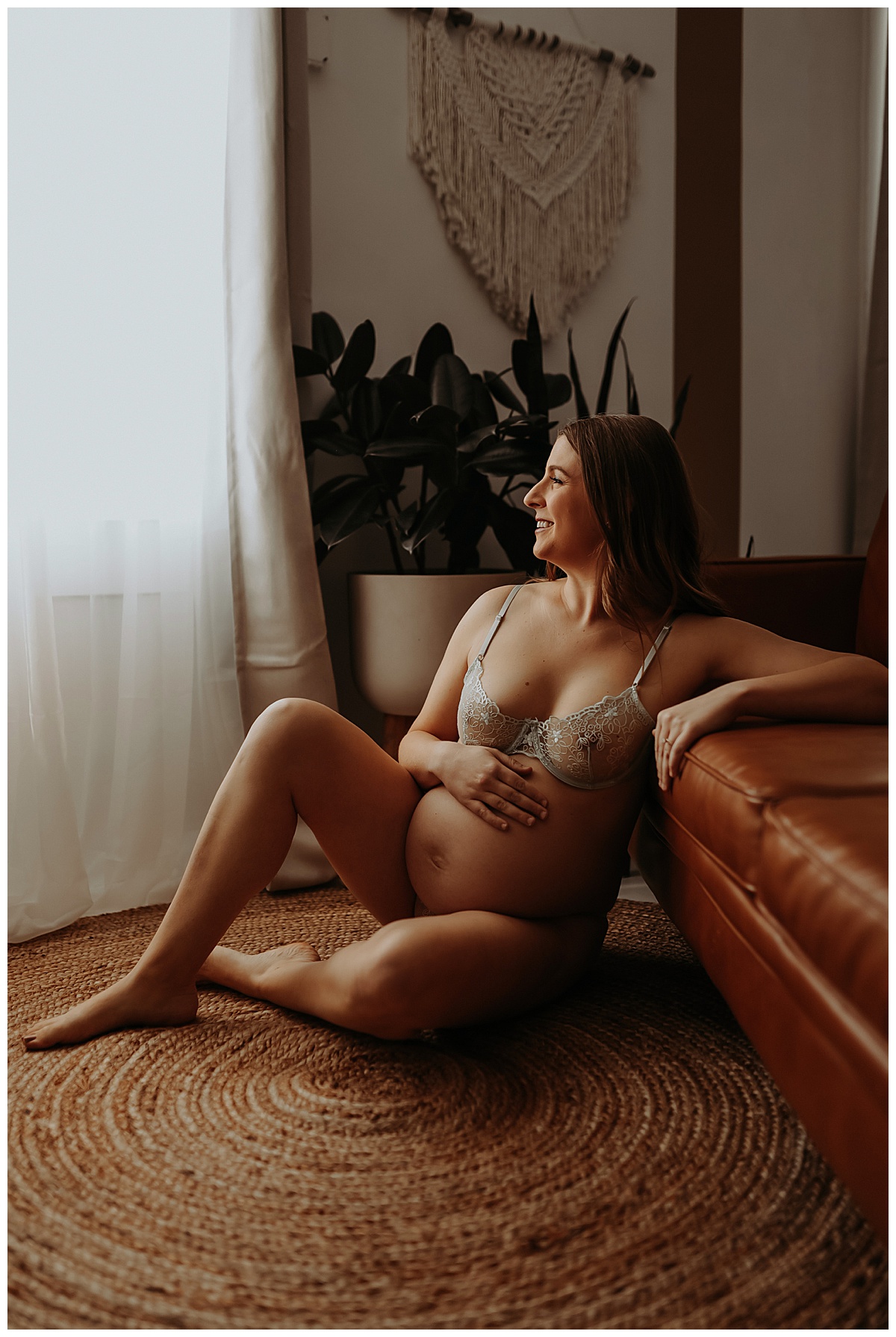 Mother sits down and holds belly close for Minneapolis Boudoir Photographer