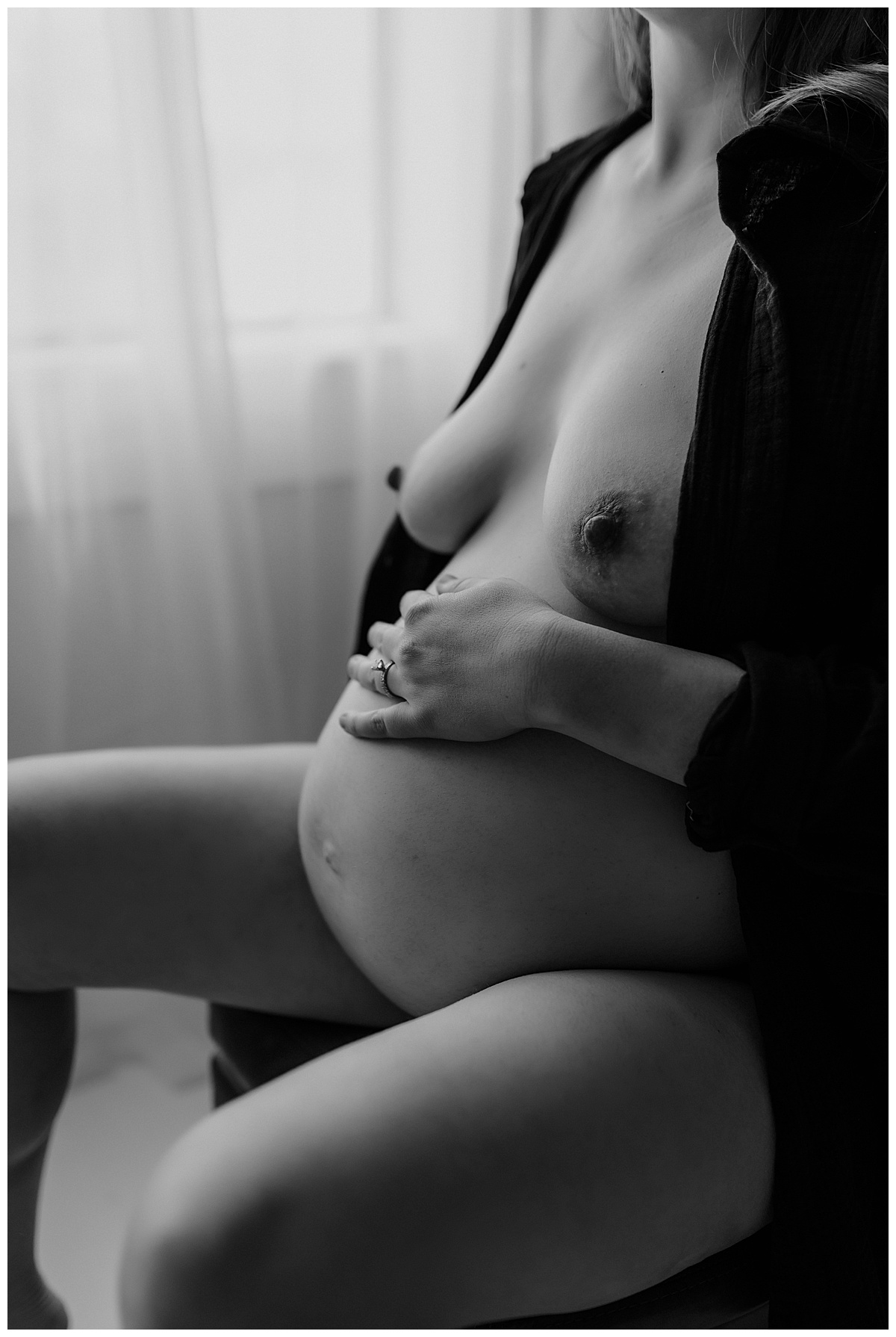 Pregnant lady grabs belly softy for Maternity Boudoir session