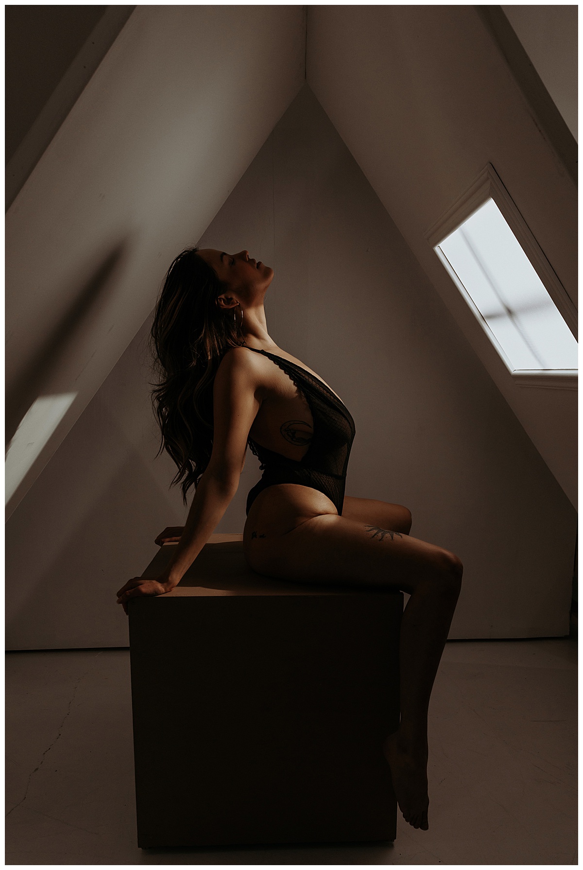 Lady leans back wearing black lingerie for Sultry Skylight Session