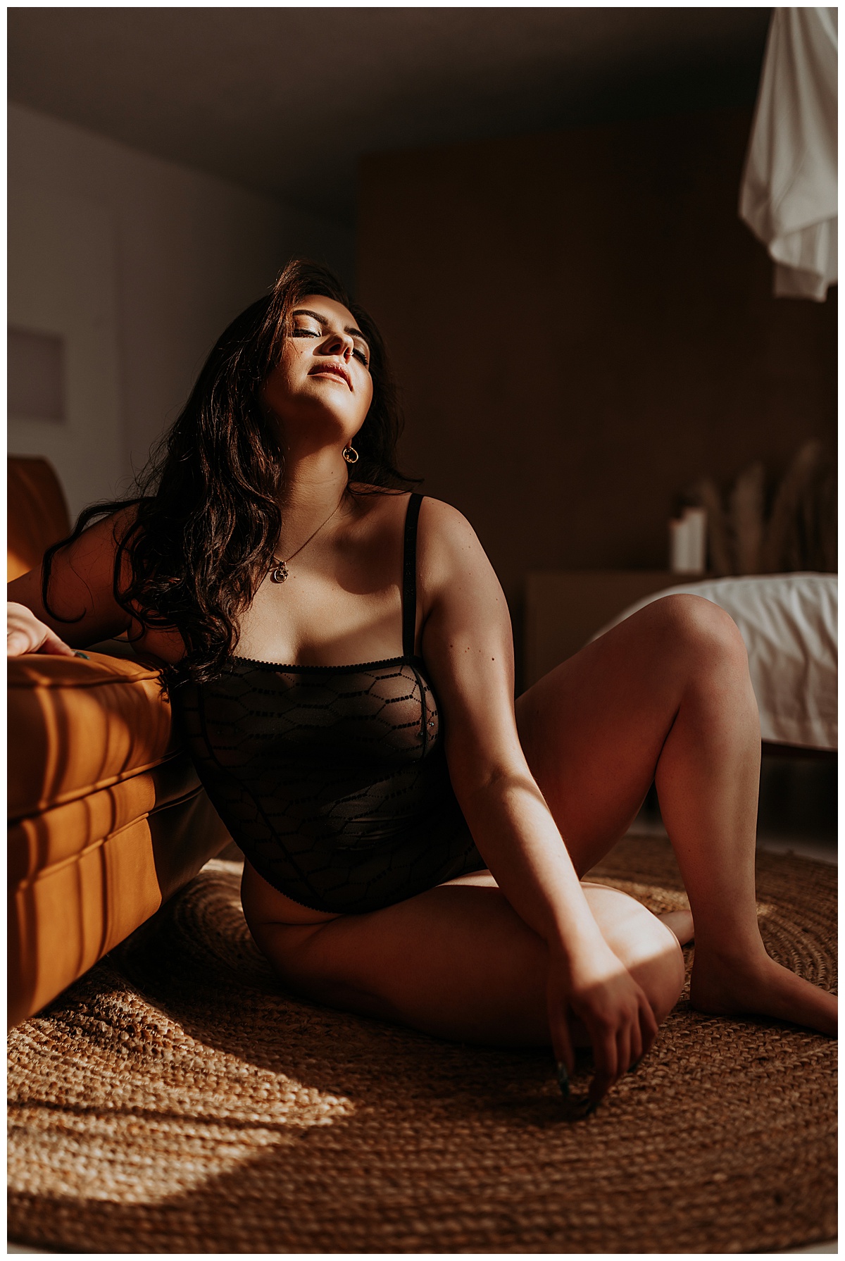 Lady sits on floor against couch for  Minneapolis Boudoir Photographer