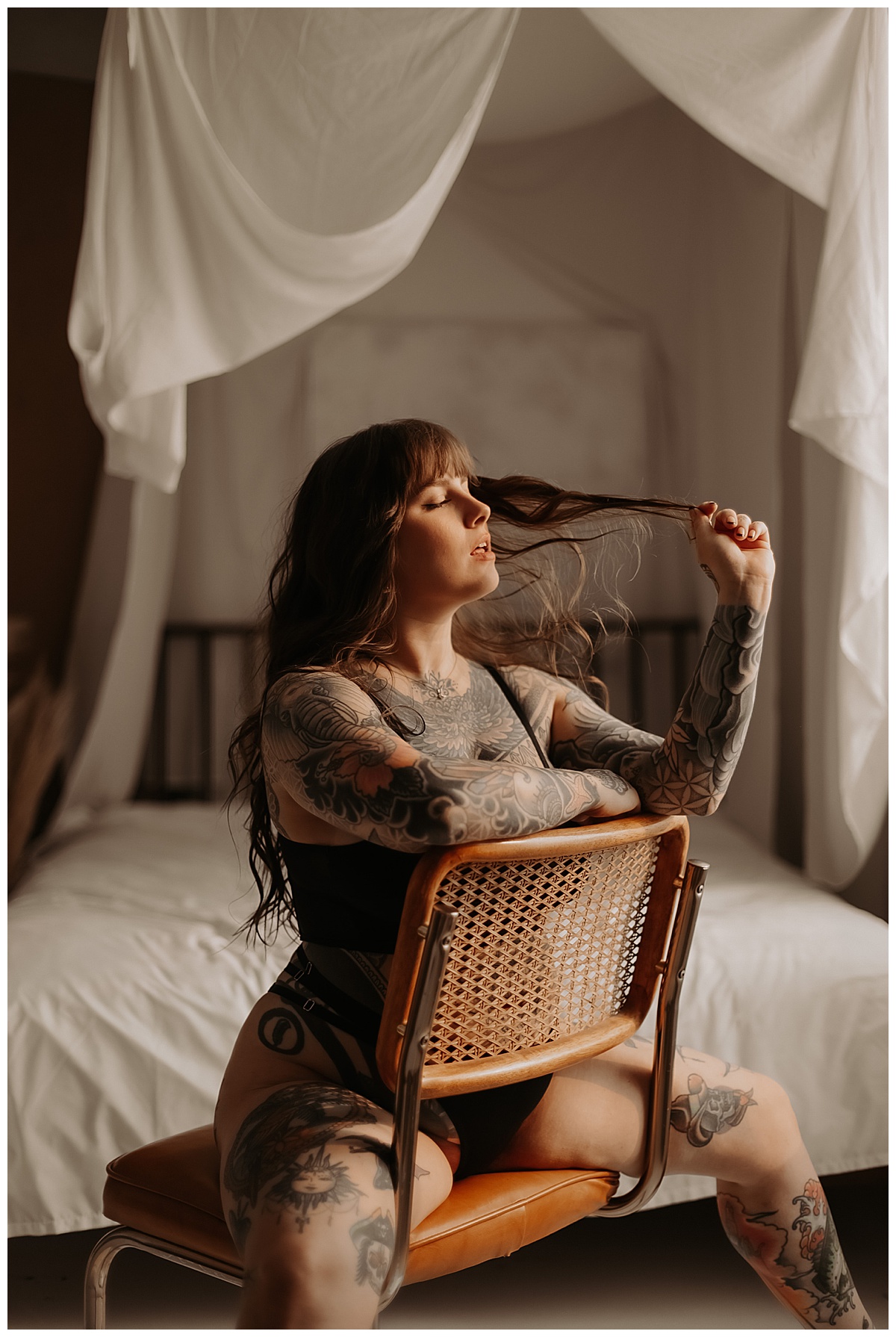 Woman grabs her hair while sitting in chair for Boudoir Quickie Sessions