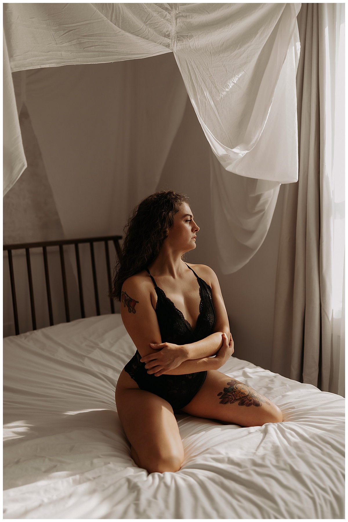 Lady kneels on the bed wearing black lingerie for Mary Castillo Photography