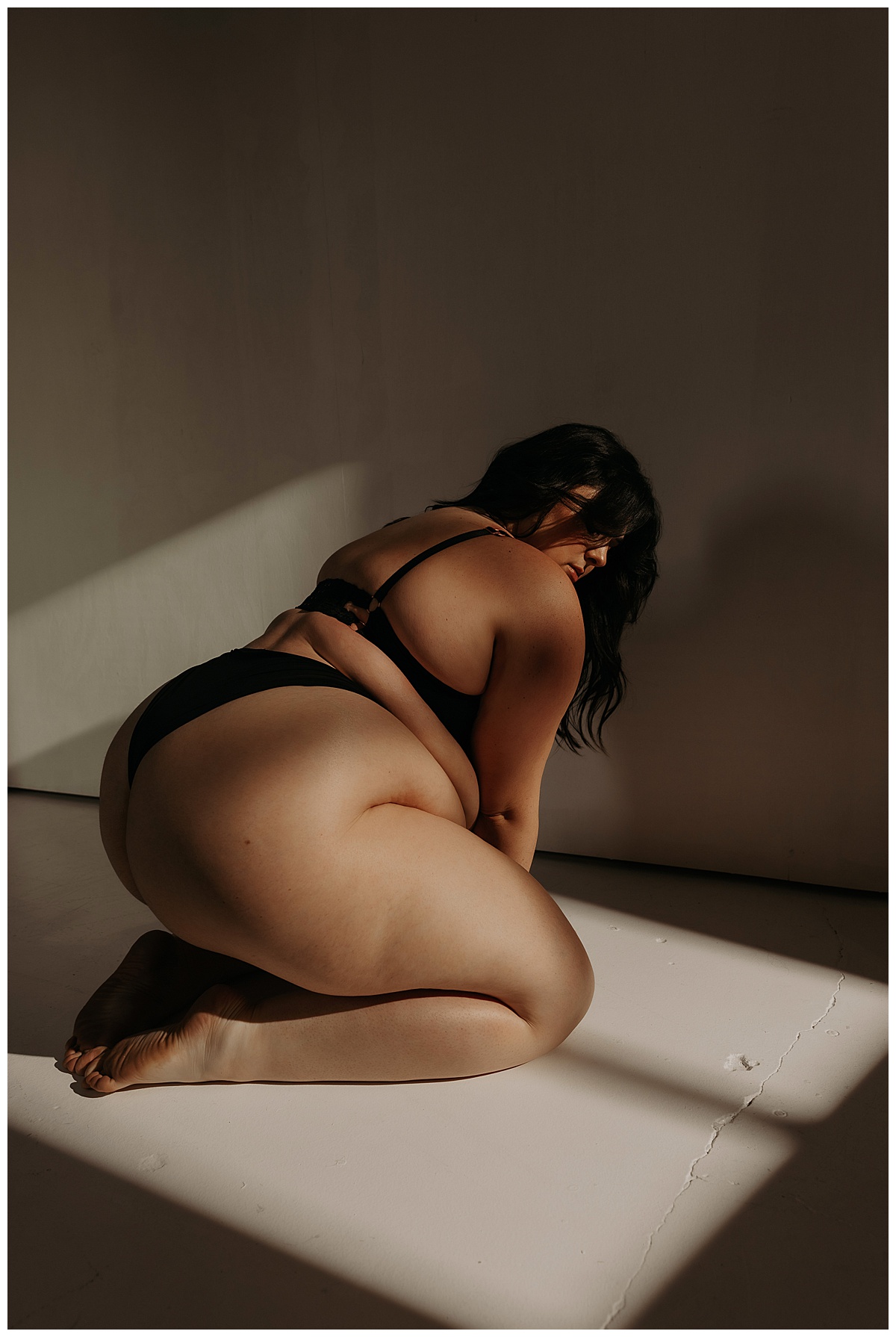 Girl leans forward and kneels down for Minneapolis Boudoir Photographer