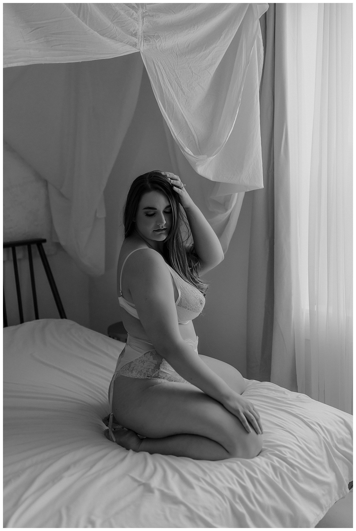 A girl holds her hand on top her head in lingerie for Minneapolis Boudoir Photographer