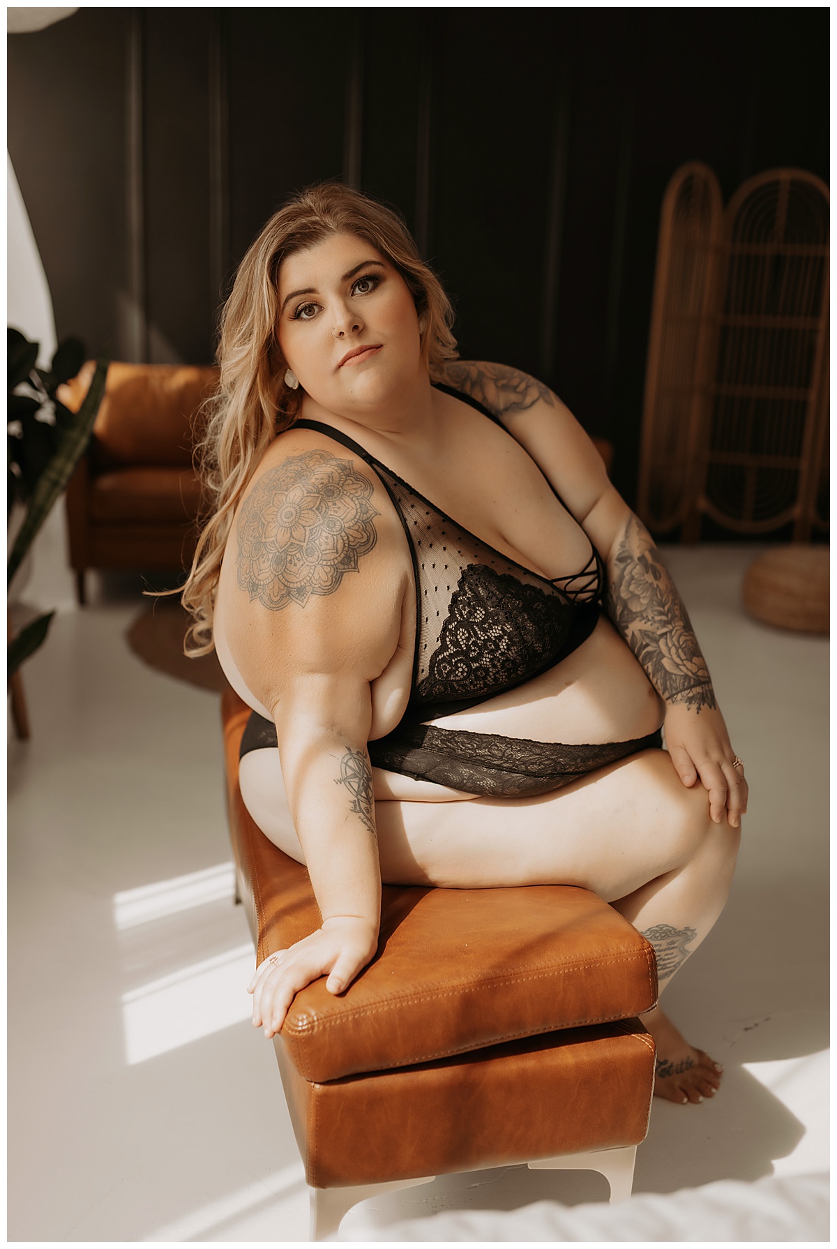 Adult sits on the bench wearing black lingerie from Torrid Lingerie