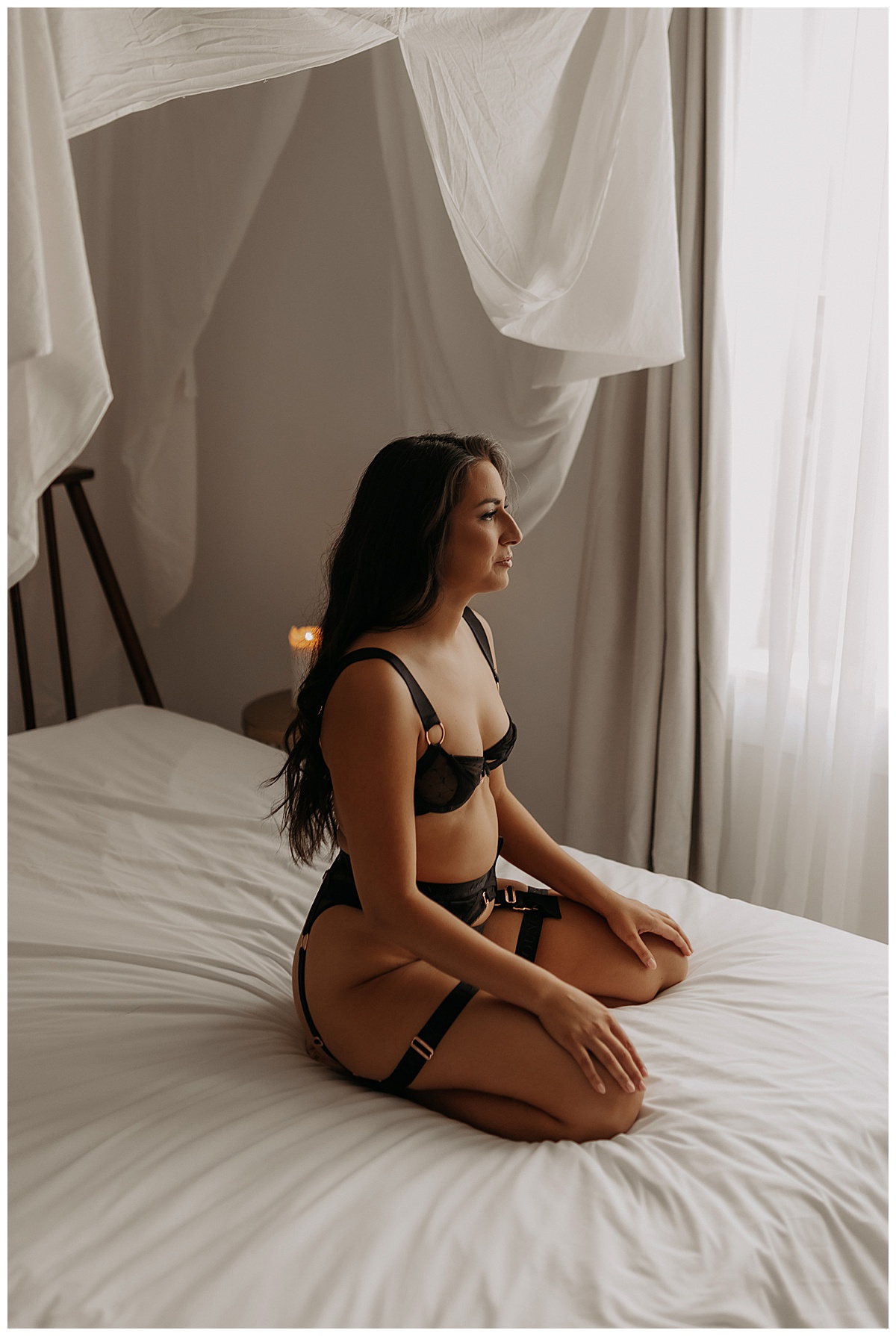 Woman kneels on bed wearing black strappy lingerie before Celebrating In Your Birthday Suit