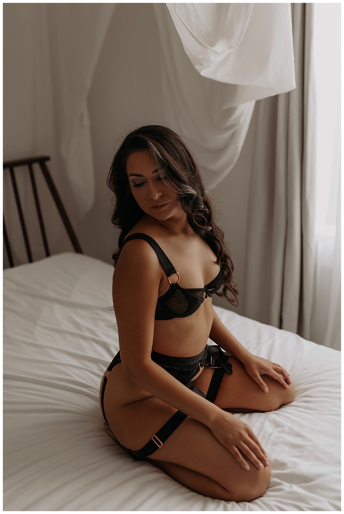 Adult sits on bed in black lingerie for Mary Castillo Photography