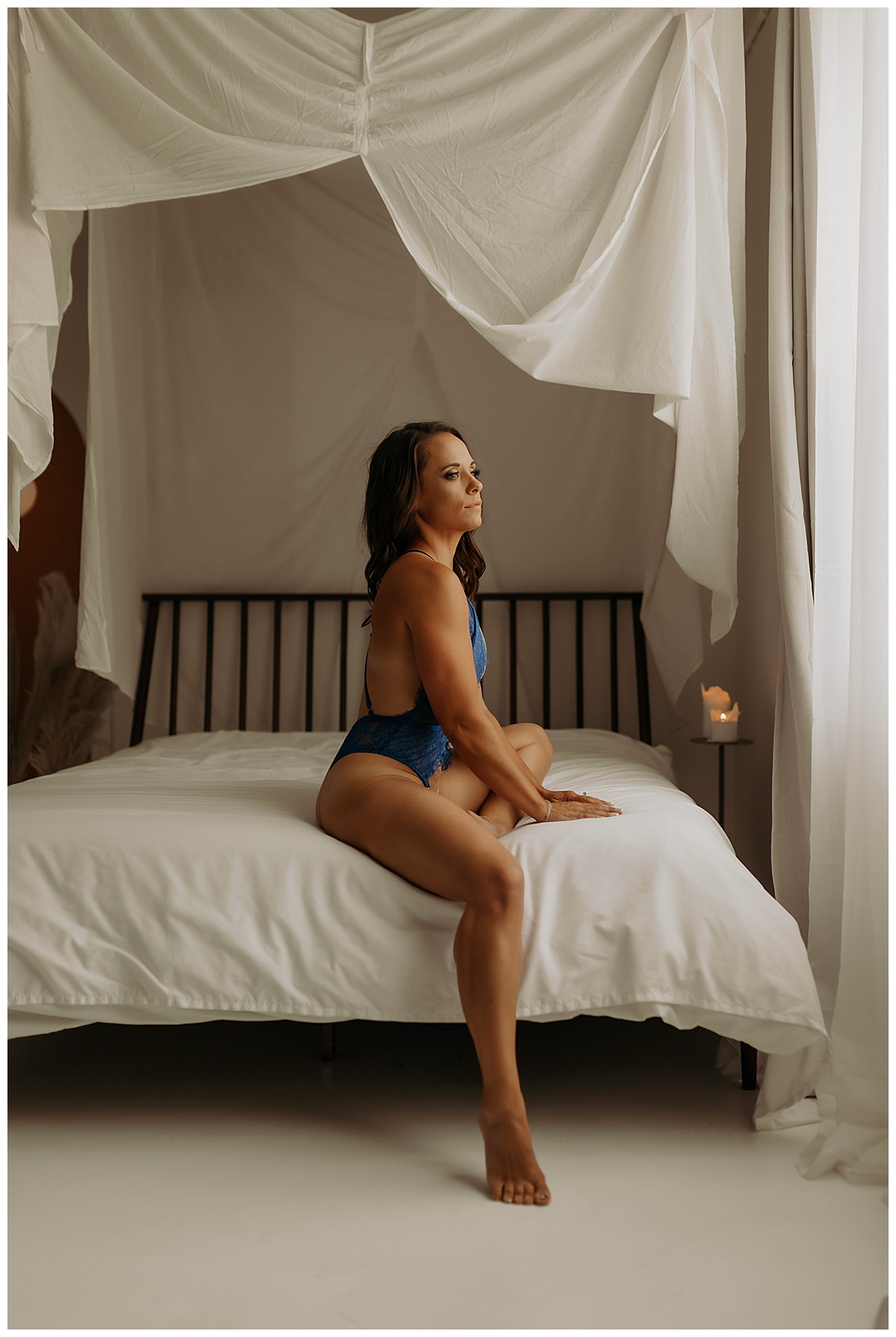 Woman sits on the edge of the bed for Minneapolis Boudoir Photographer