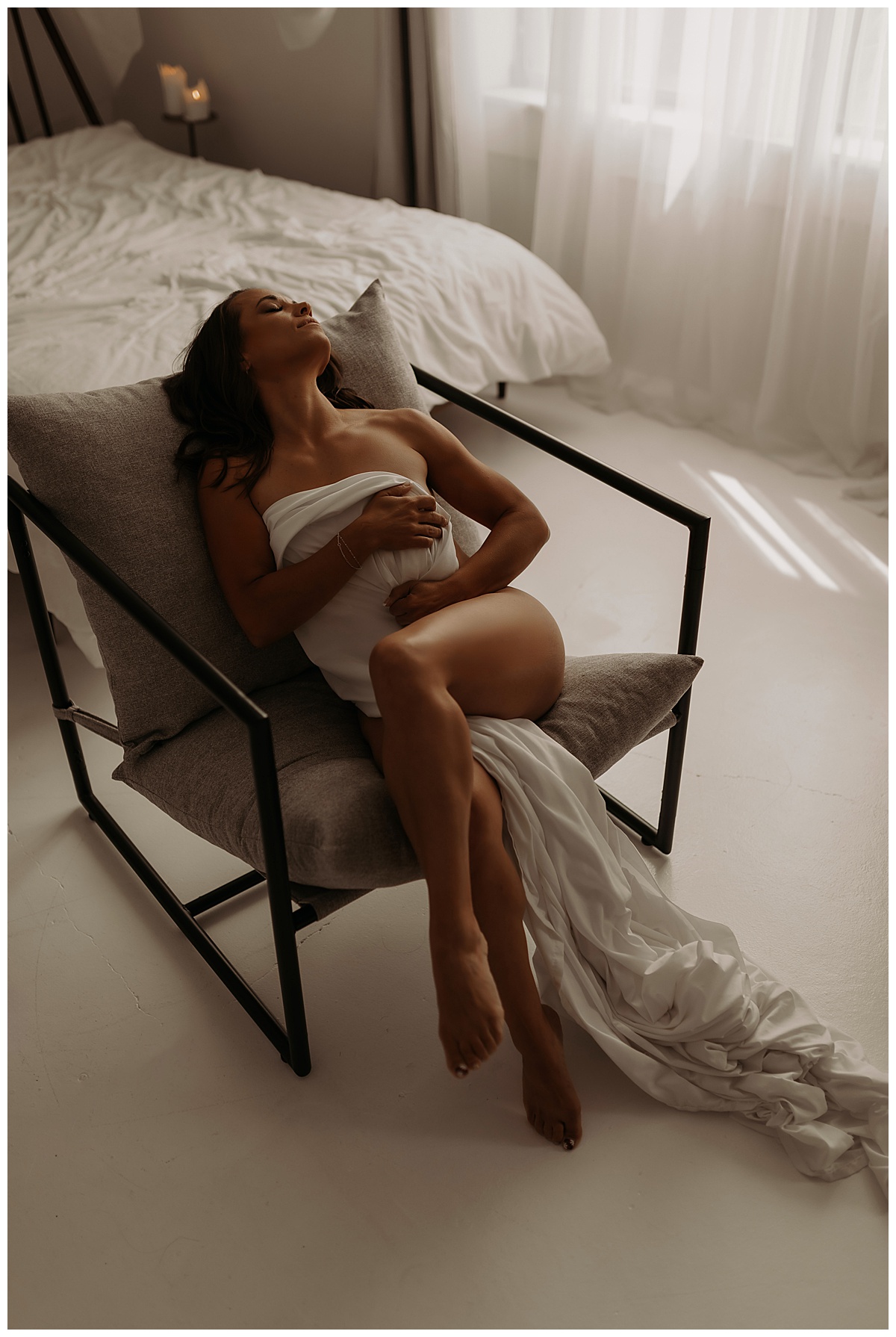 Woman covers her body with white sheet for Minneapolis Boudoir Photographer
