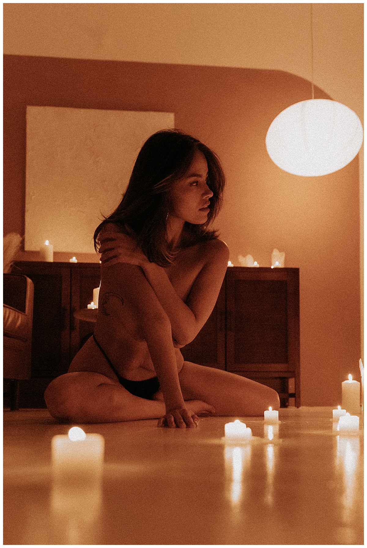 Adult lays on the floor with candles for Minneapolis Boudoir Photographer