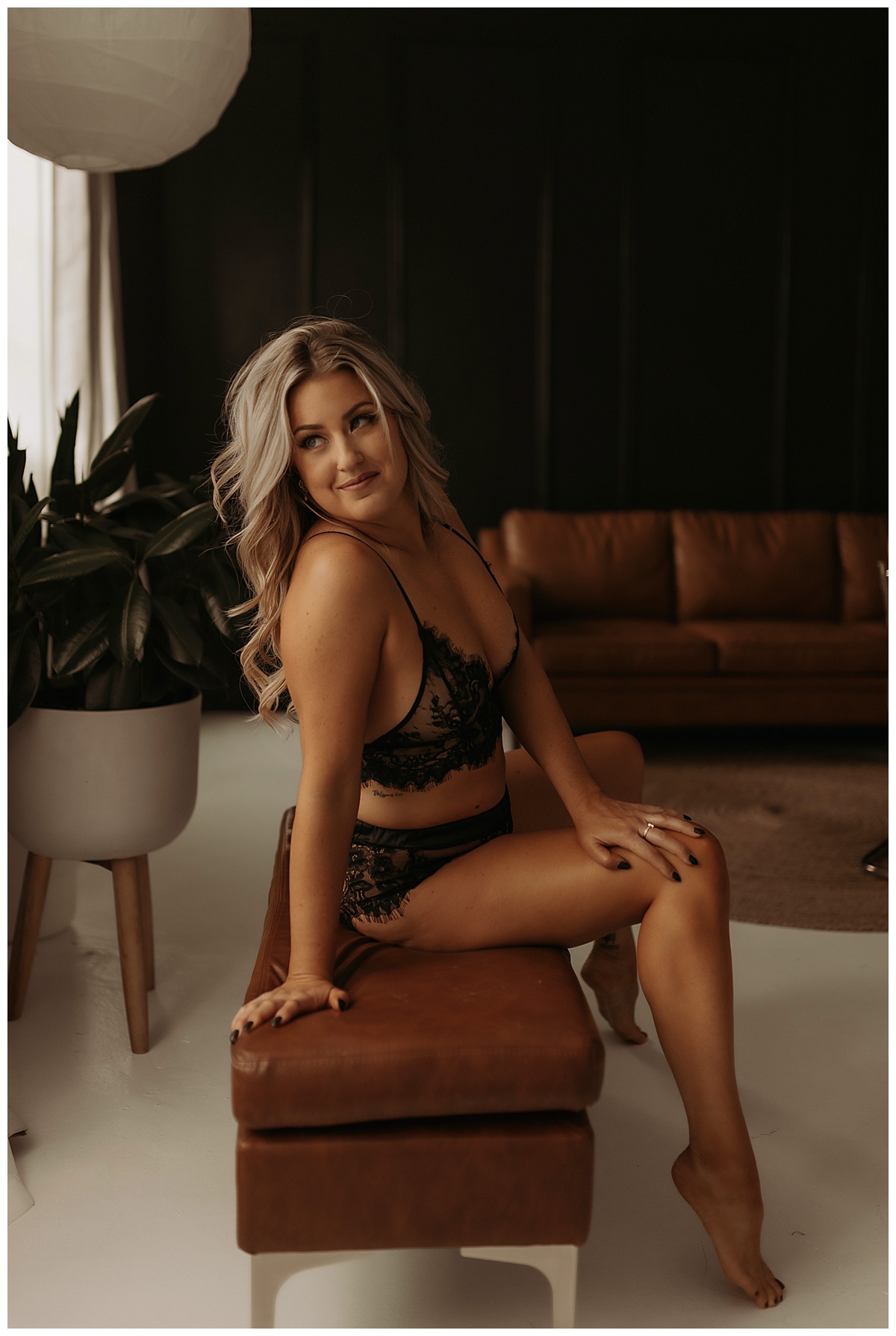 Female sits on the chair wearing black lace lingerie for Minneapolis Boudoir Photographer