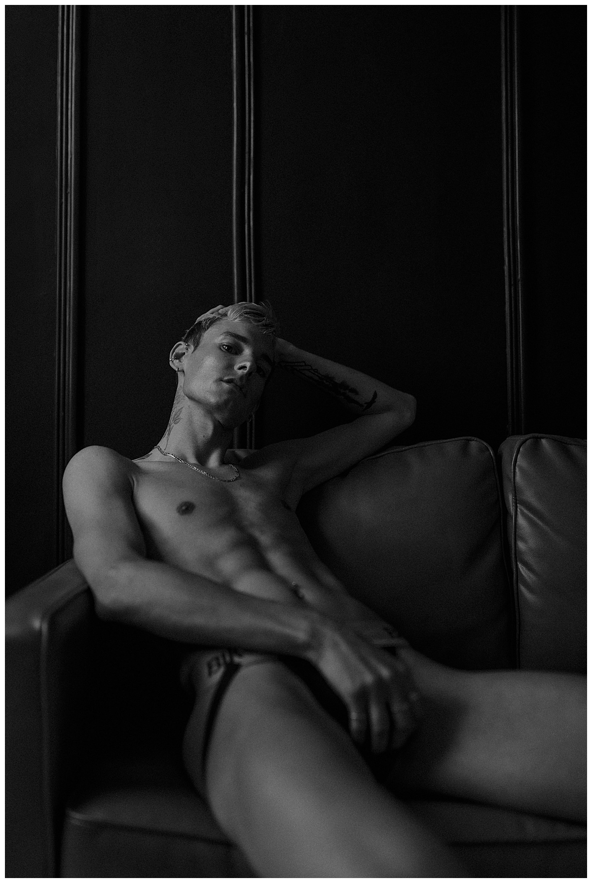 Person lays on the couch during his Male Boudoir Session
