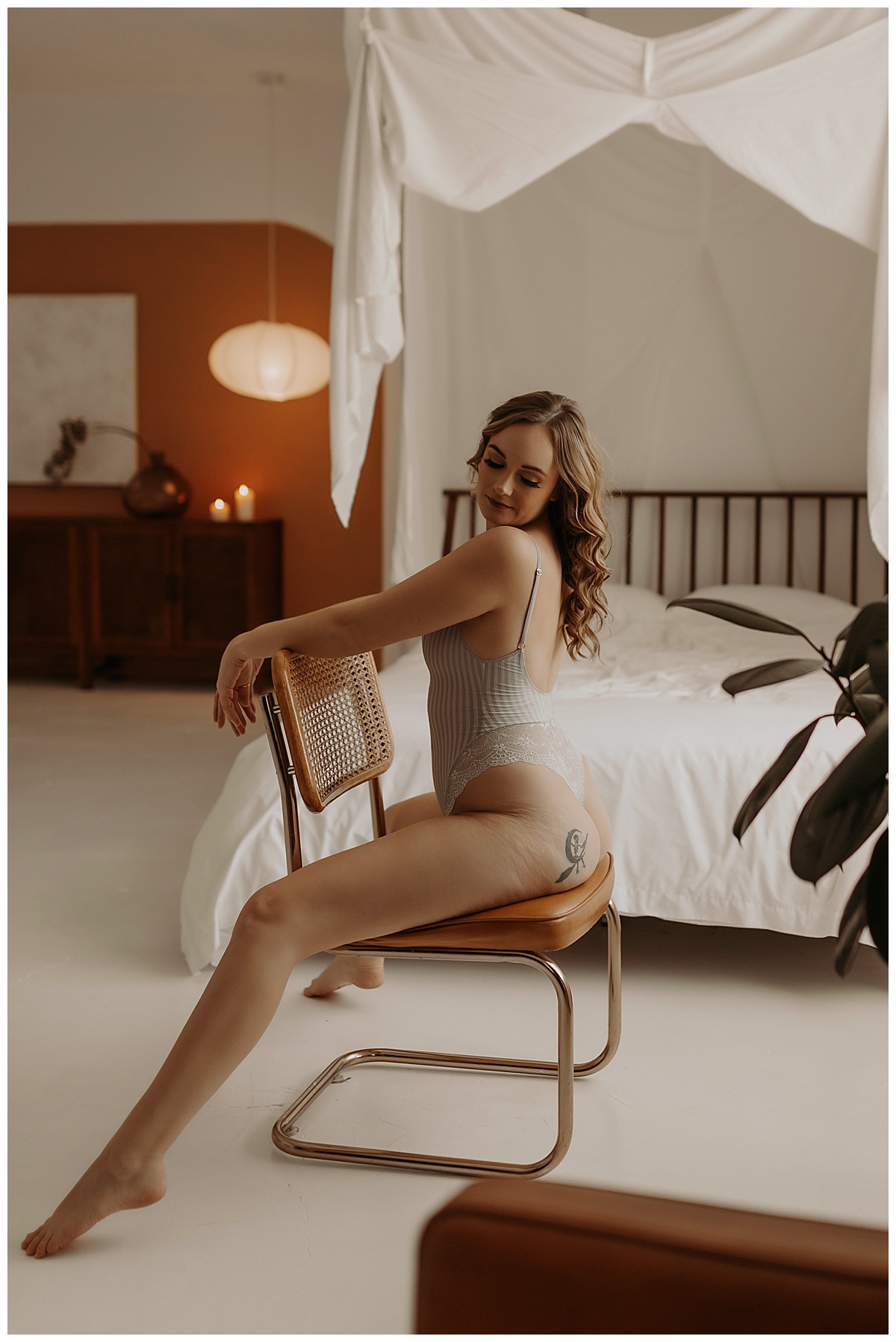 Female straddles a chair and looks over her shoulder for Mary Castillo Photography
