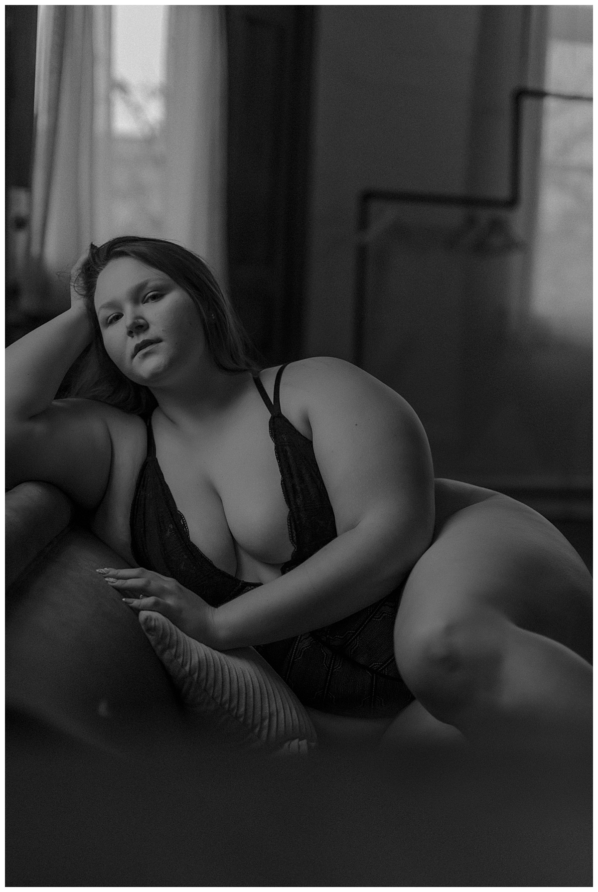 Adult sits on the couch wearing black lingerie for Mary Castillo Photography