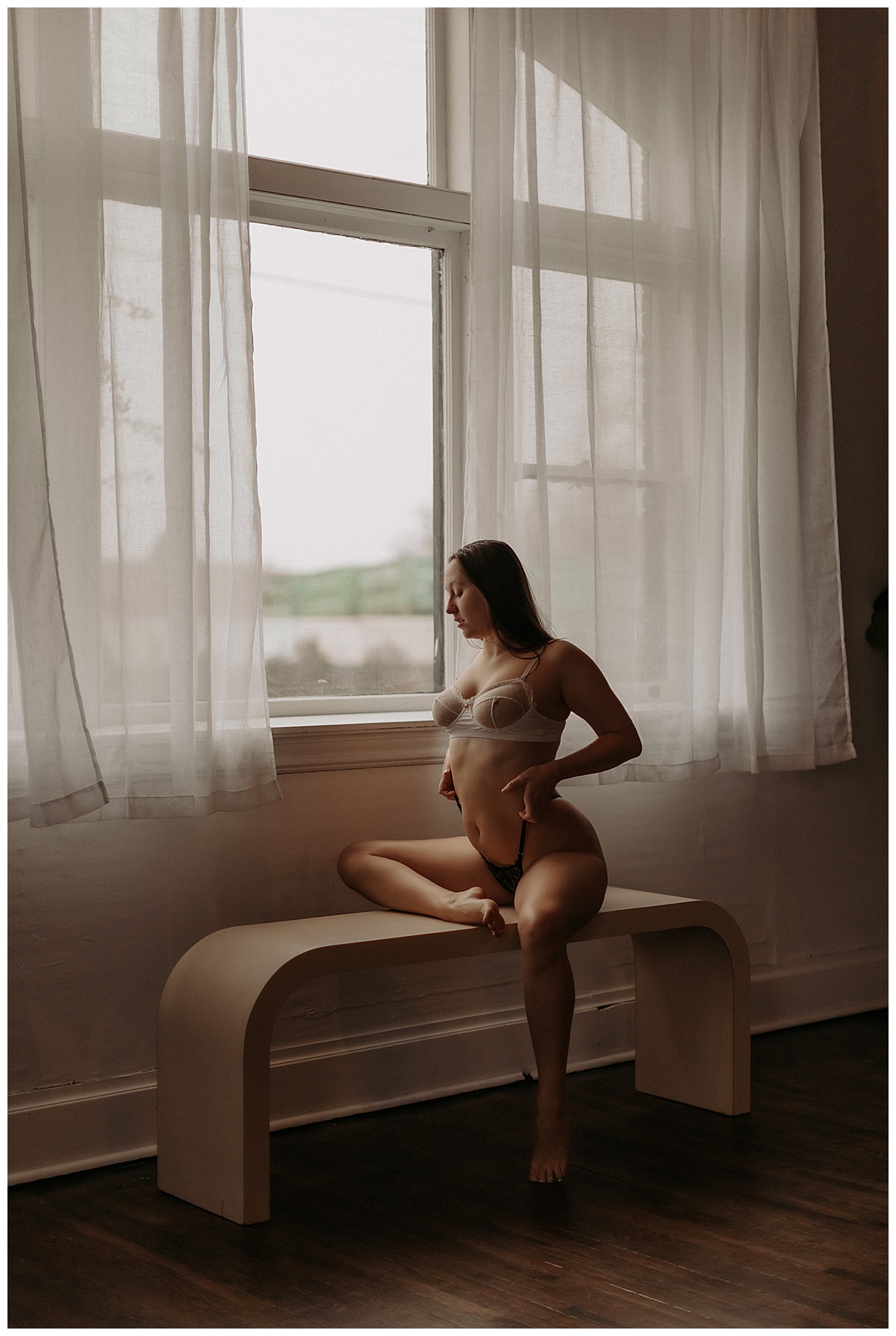 Female tugs at her lingerie for Minneapolis Boudoir Photographer
