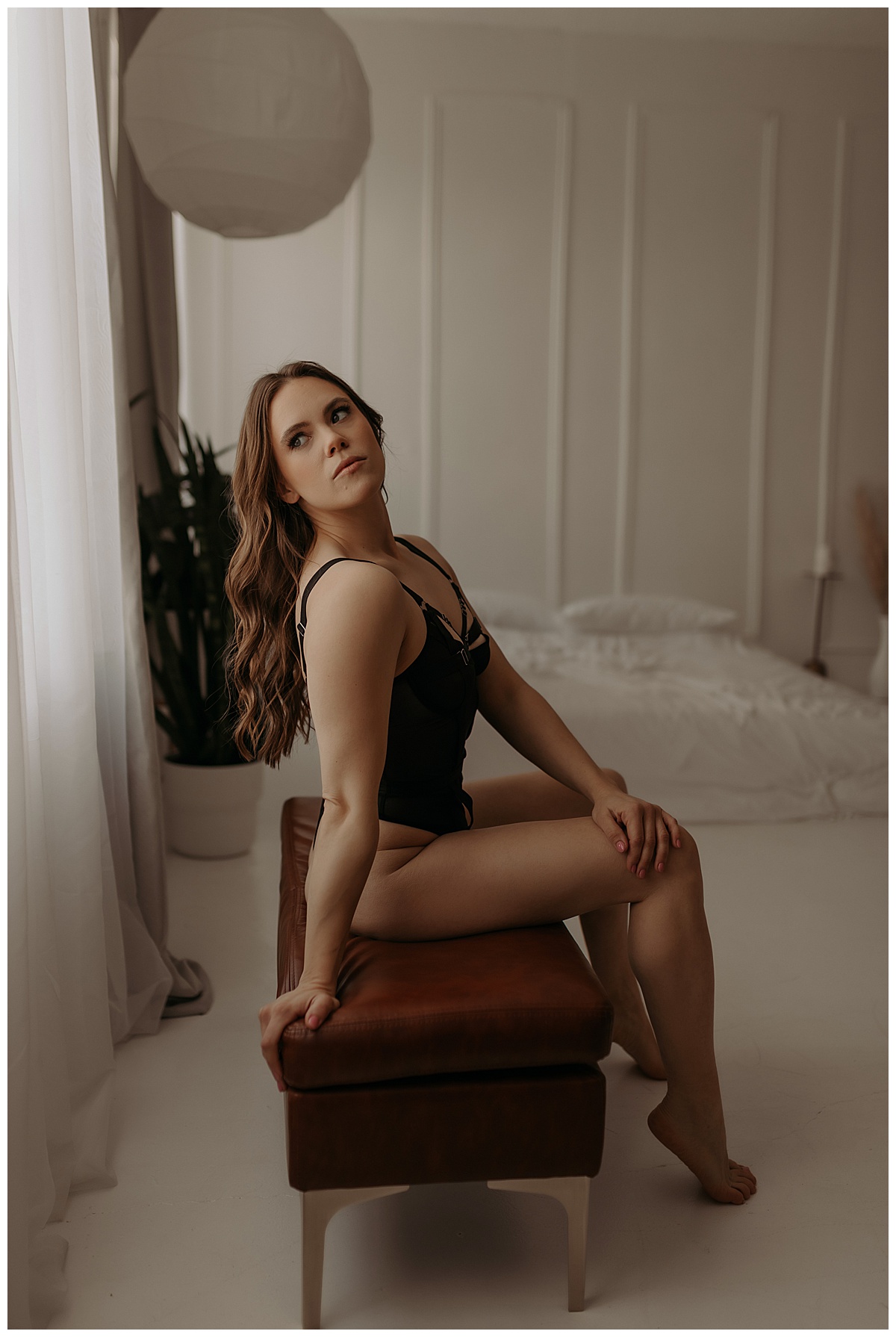 Adult sits on stool wearing black lingerie for Mary Castillo Photography