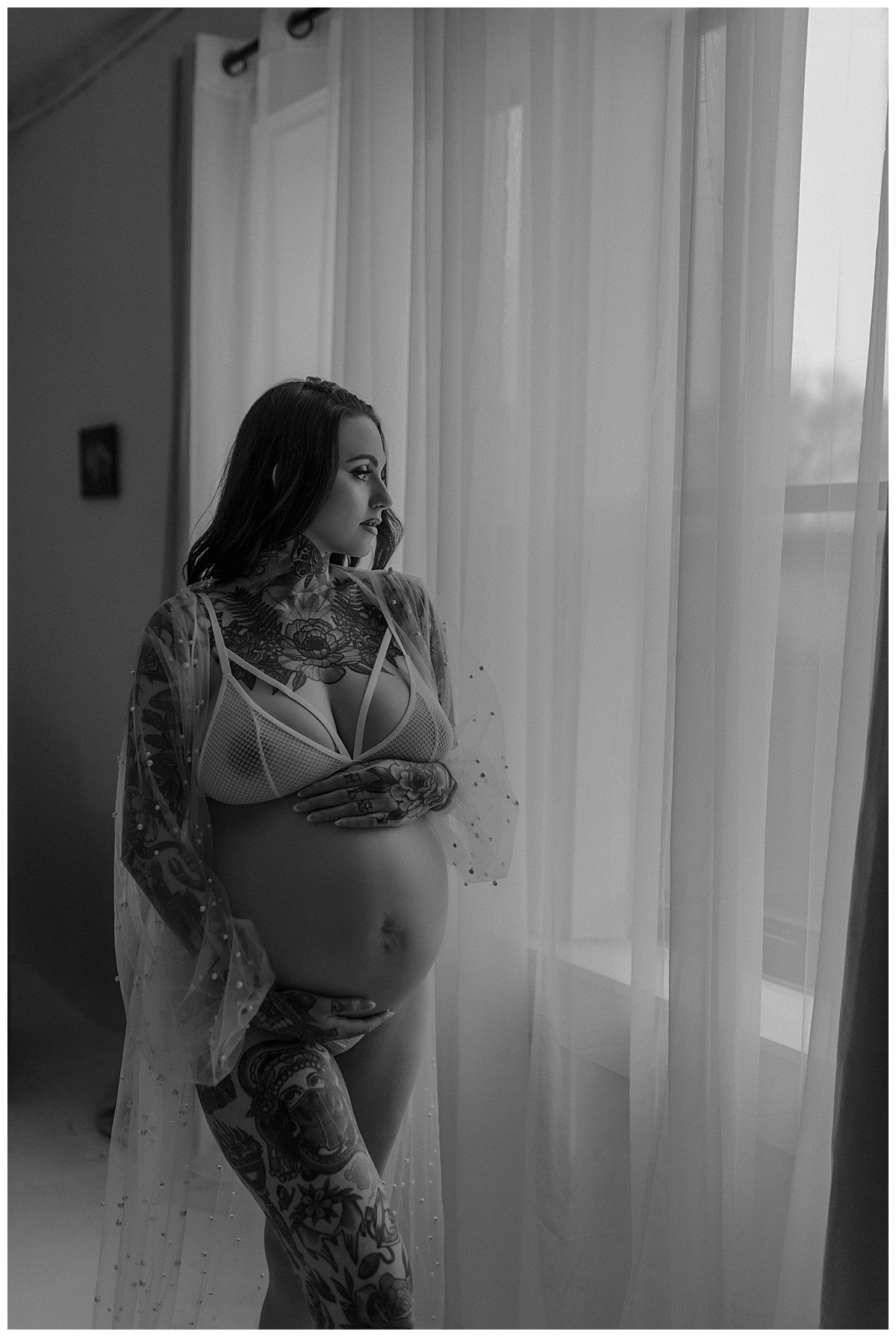 Adult wraps hands around baby bump during her Maternity Boudoir Session
