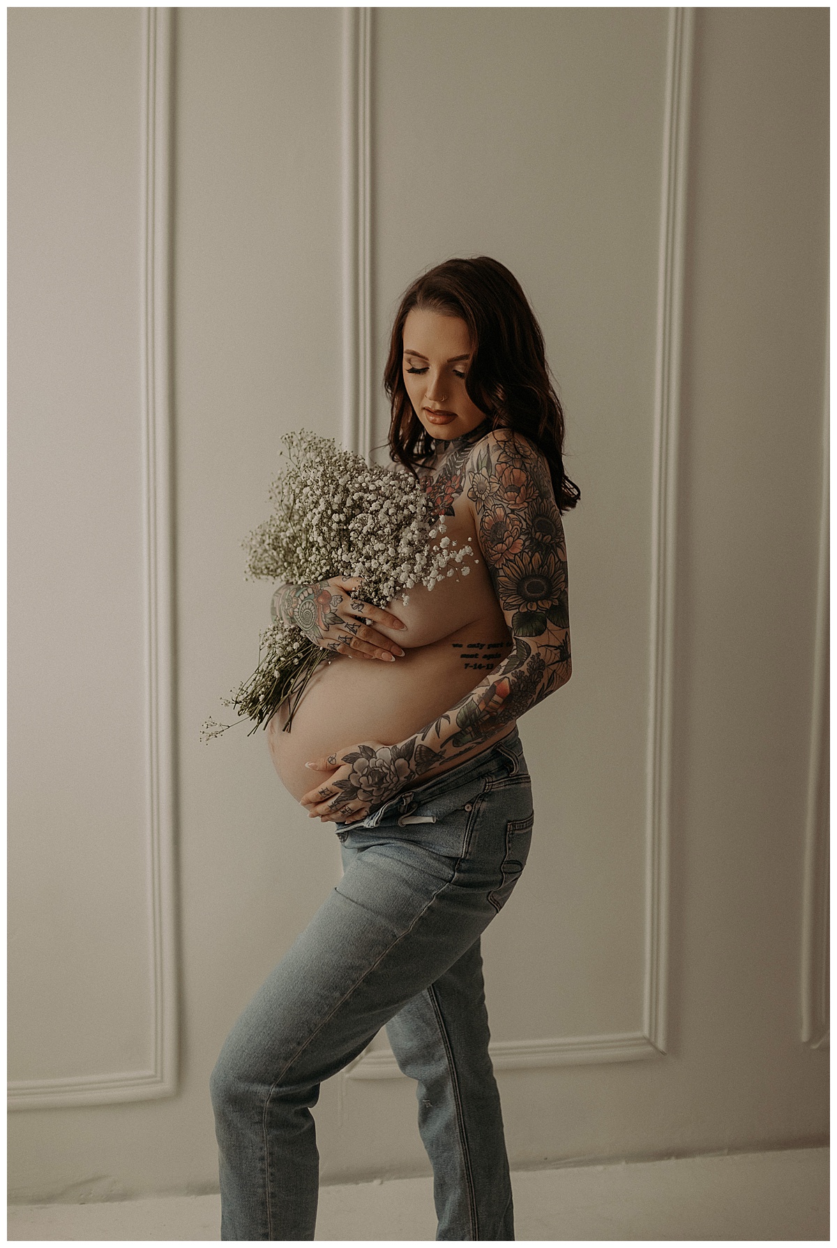 Woman cover her pregnant belly with bouquet of flowers for Mary Castillo Photography