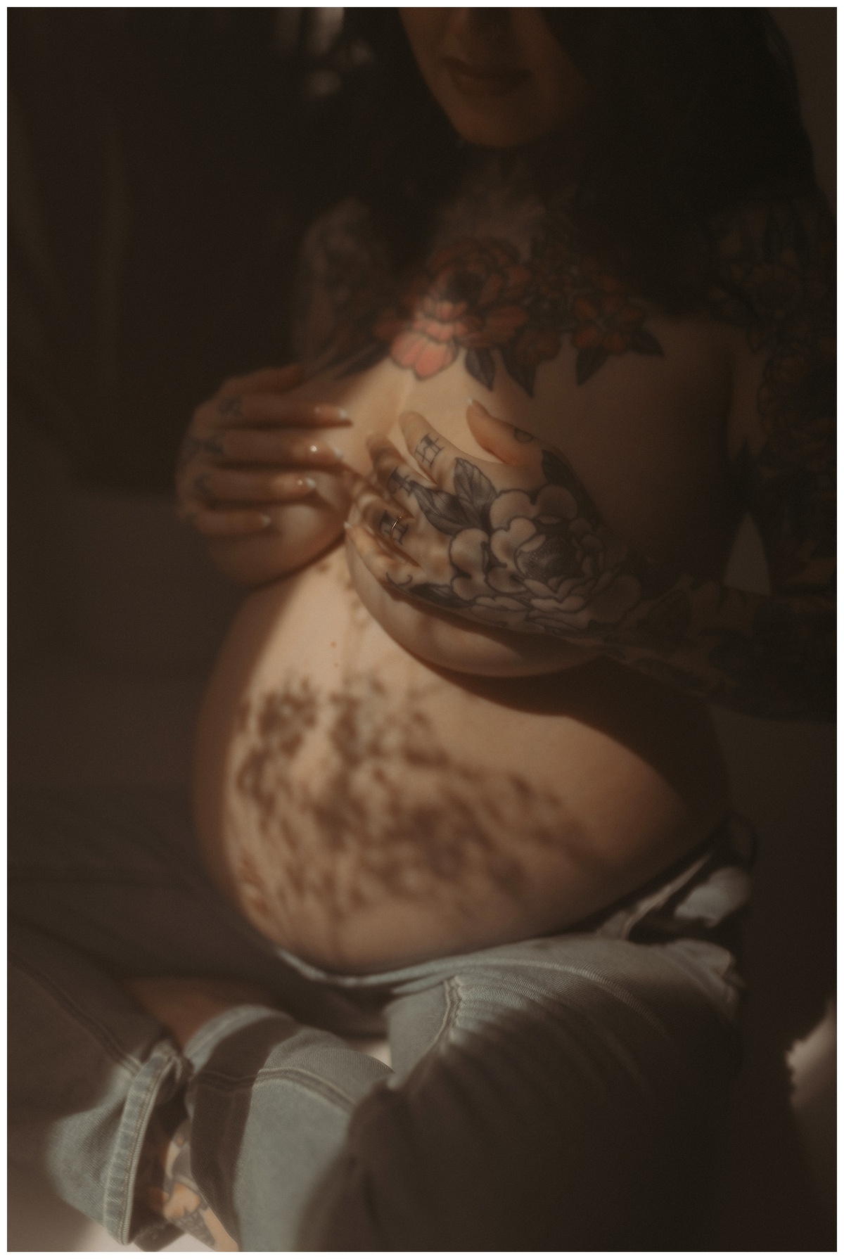 Person covers her chest with her hands during her Maternity Boudoir Session