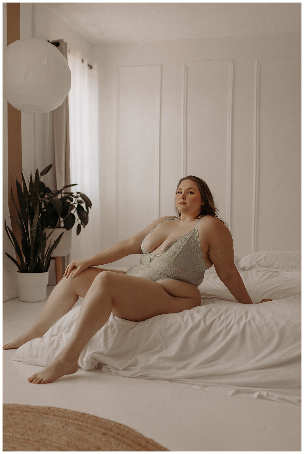 Person leans on the edge of the bed wearing lingerie for Mary Castillo Photography