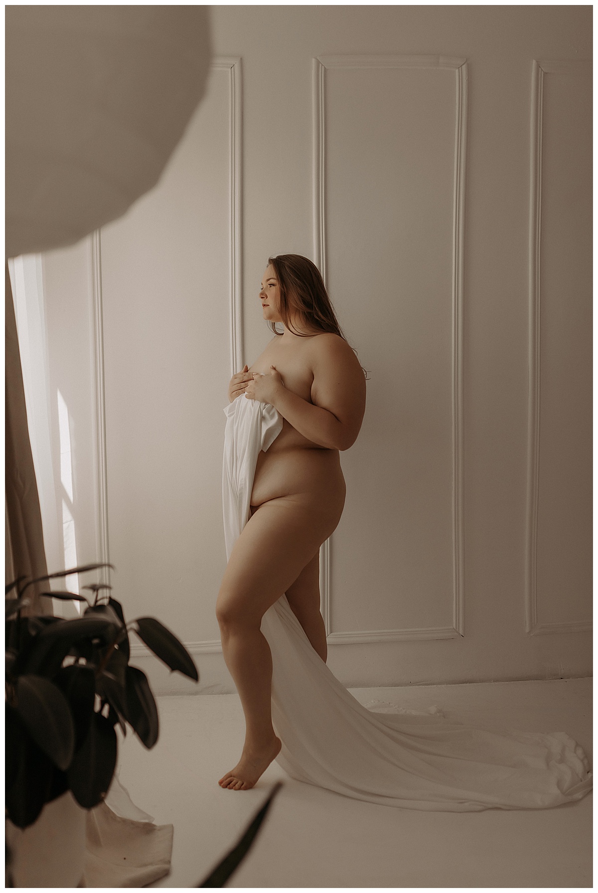 Adult covers chest and body with with white sheet for Minneapolis Boudoir Photographer