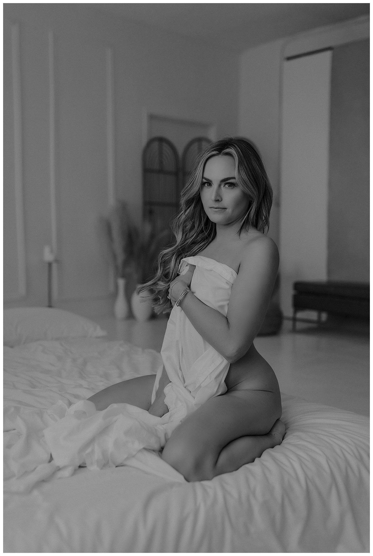 Adult covers her body with white sheets for Minneapolis Boudoir Photographer