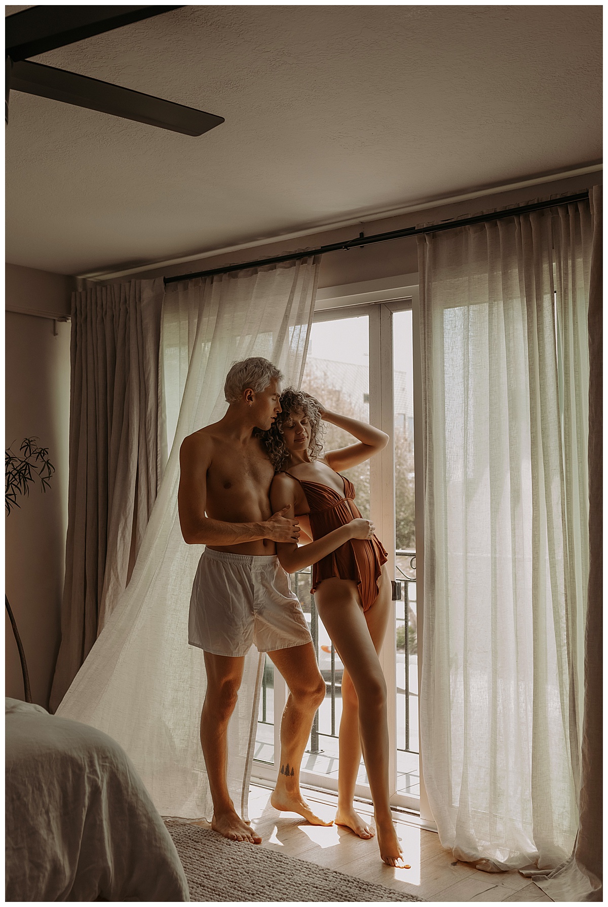 Couple stand together in front of window for Minneapolis Boudoir Photographer