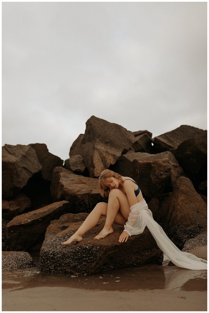 Woman sits on a rock showing Why Boudoir Photographers Should Experience A Boudoir Session 